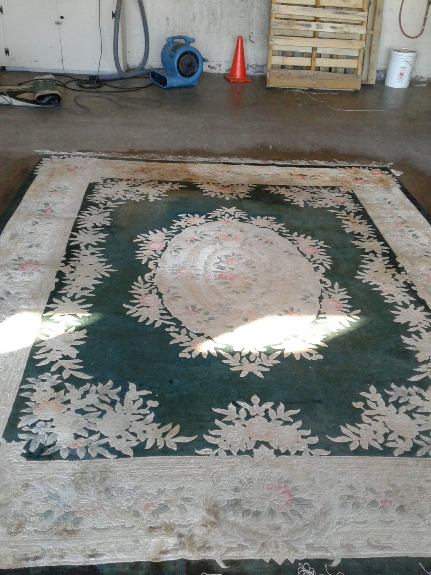 A green and white rug with a floral pattern on it
