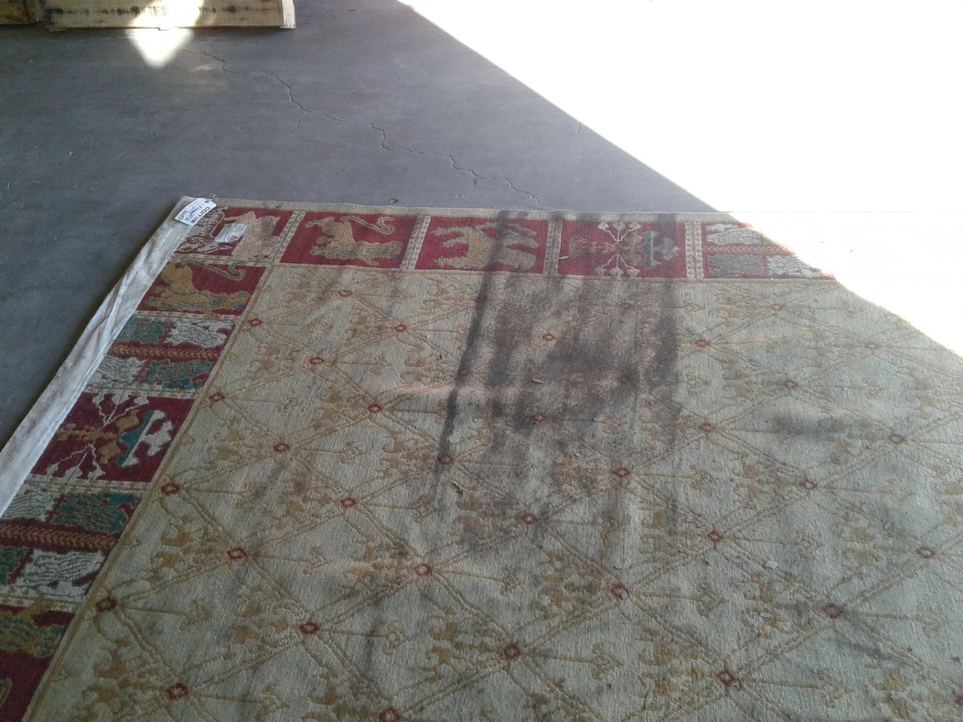 A rug is sitting on a concrete floor in a garage.