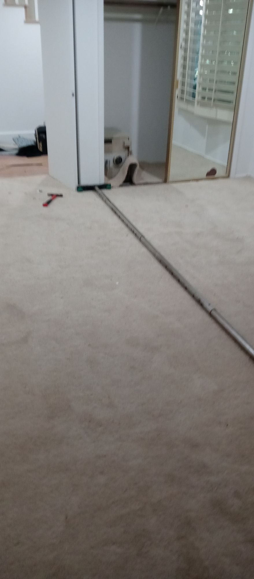 A room with a carpeted floor and a mirror on the wall.