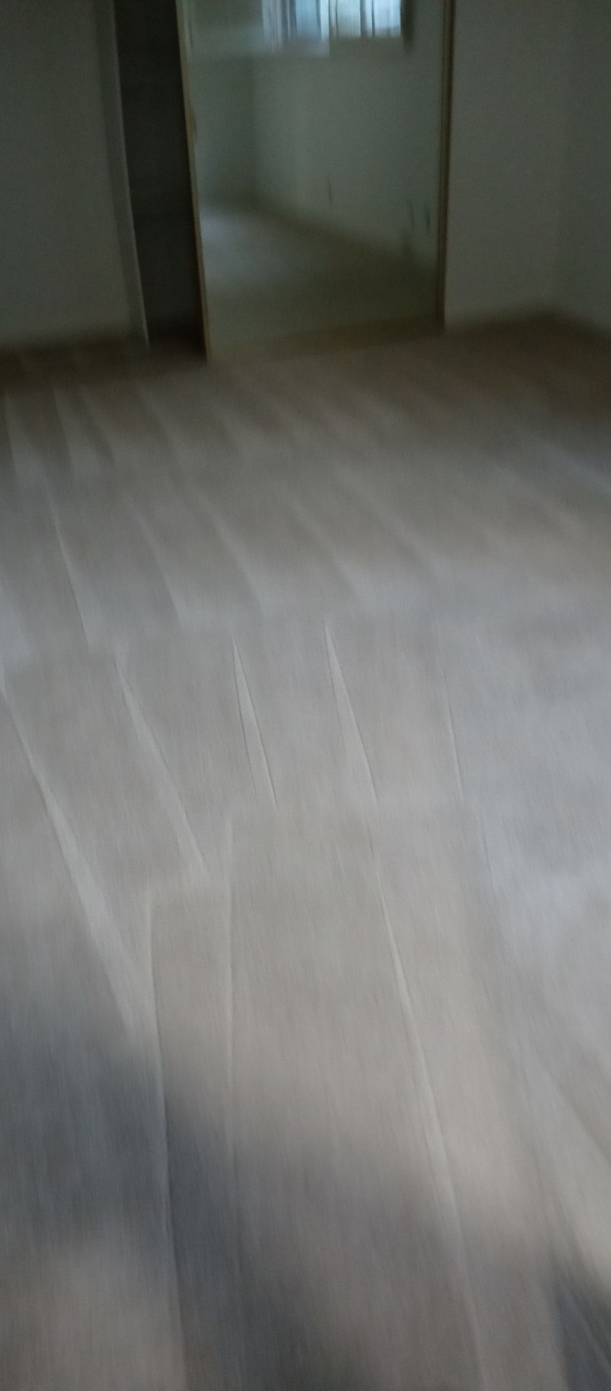 A room with a wooden floor and a window.