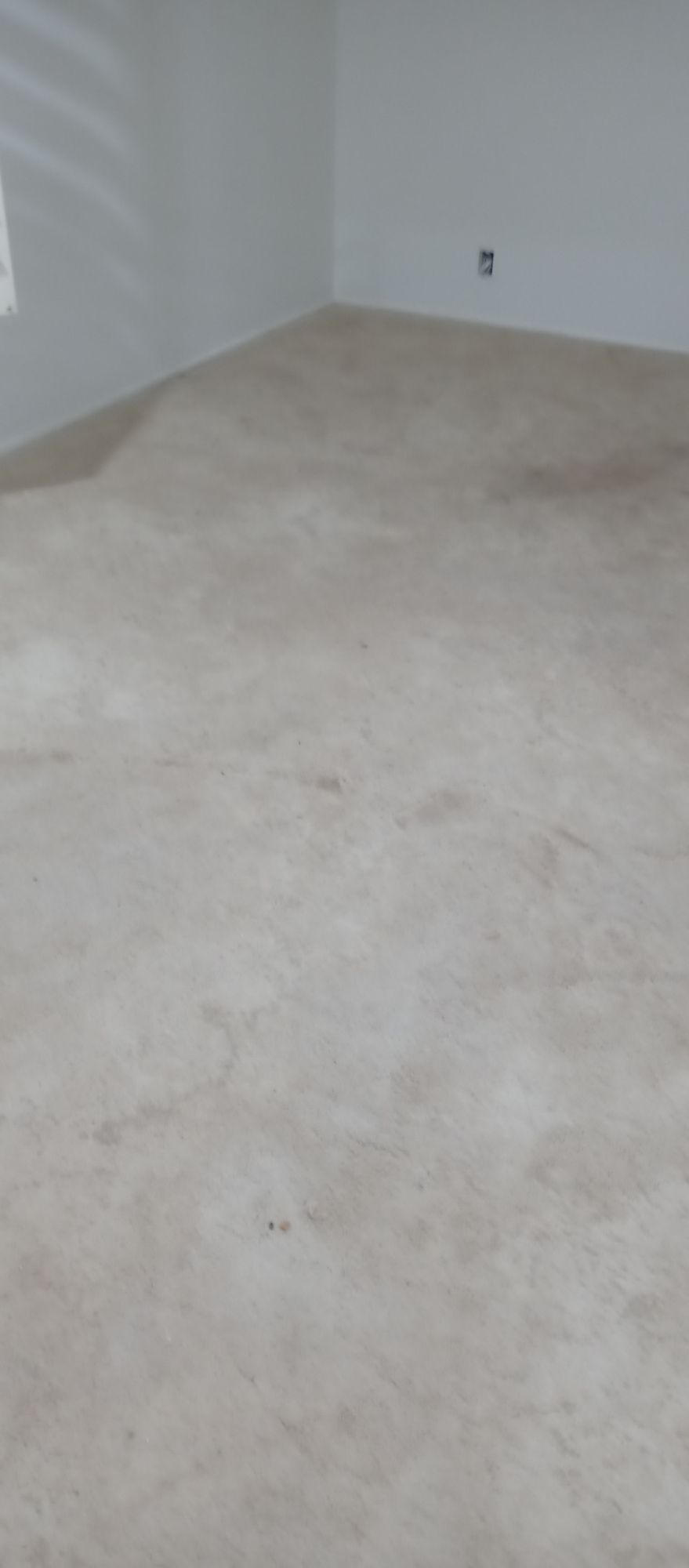 A large empty room with a carpeted floor and white walls.