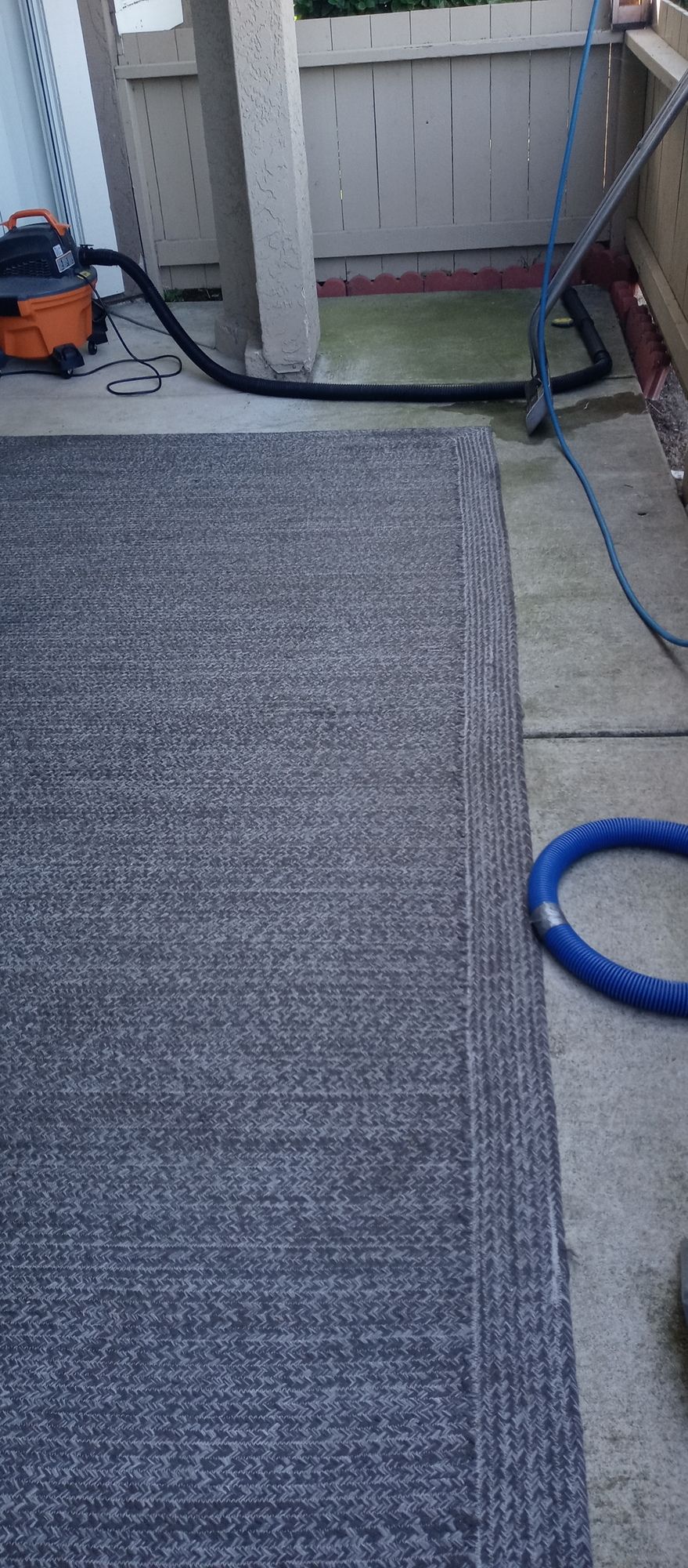 A vacuum cleaner is being used to clean a carpet.