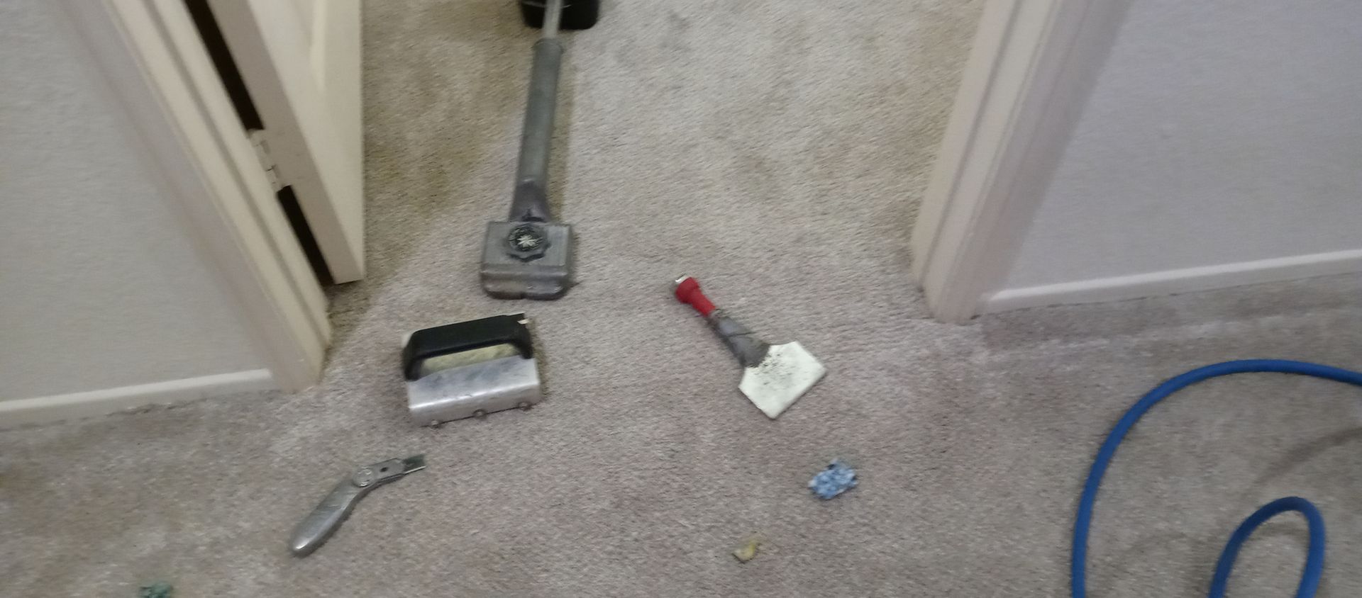 A vacuum cleaner is laying on the floor next to a spatula.