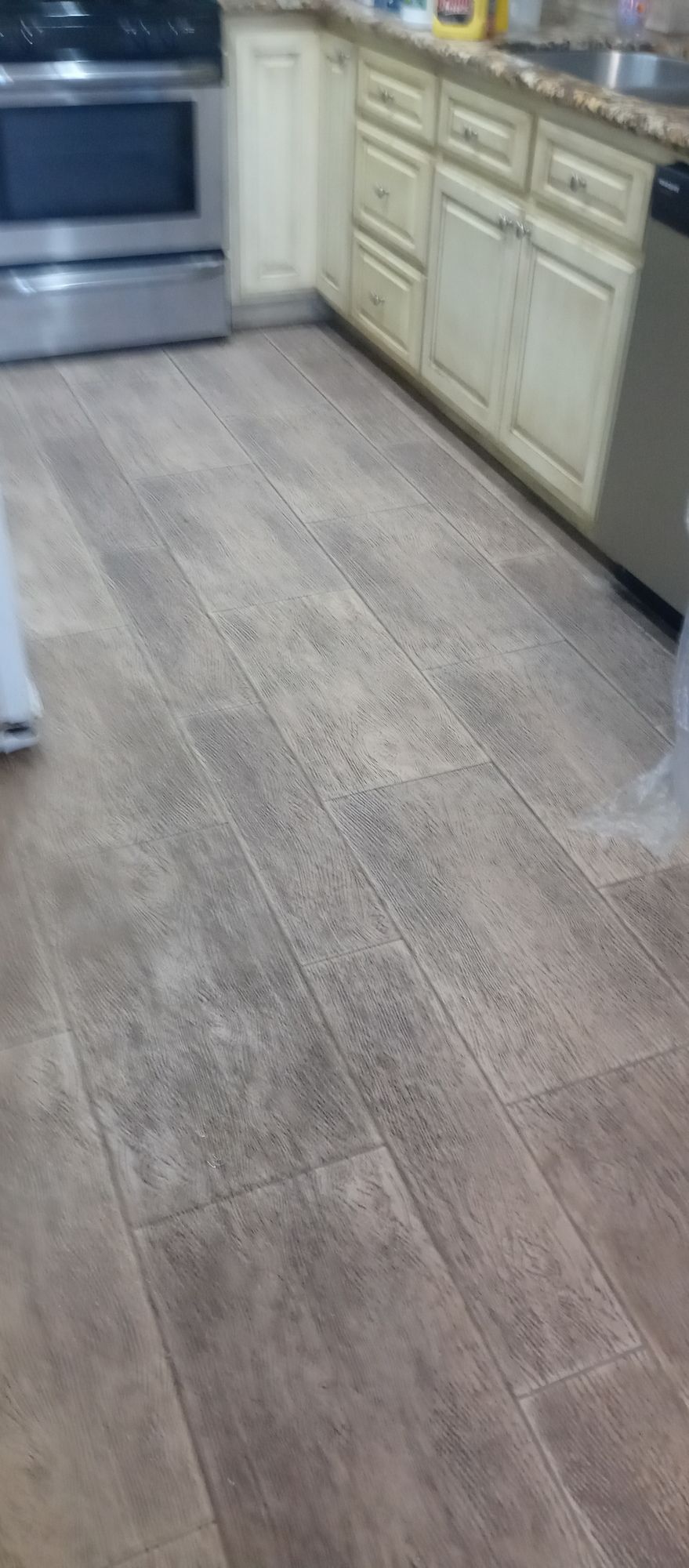 A kitchen with a wooden floor and white cabinets.