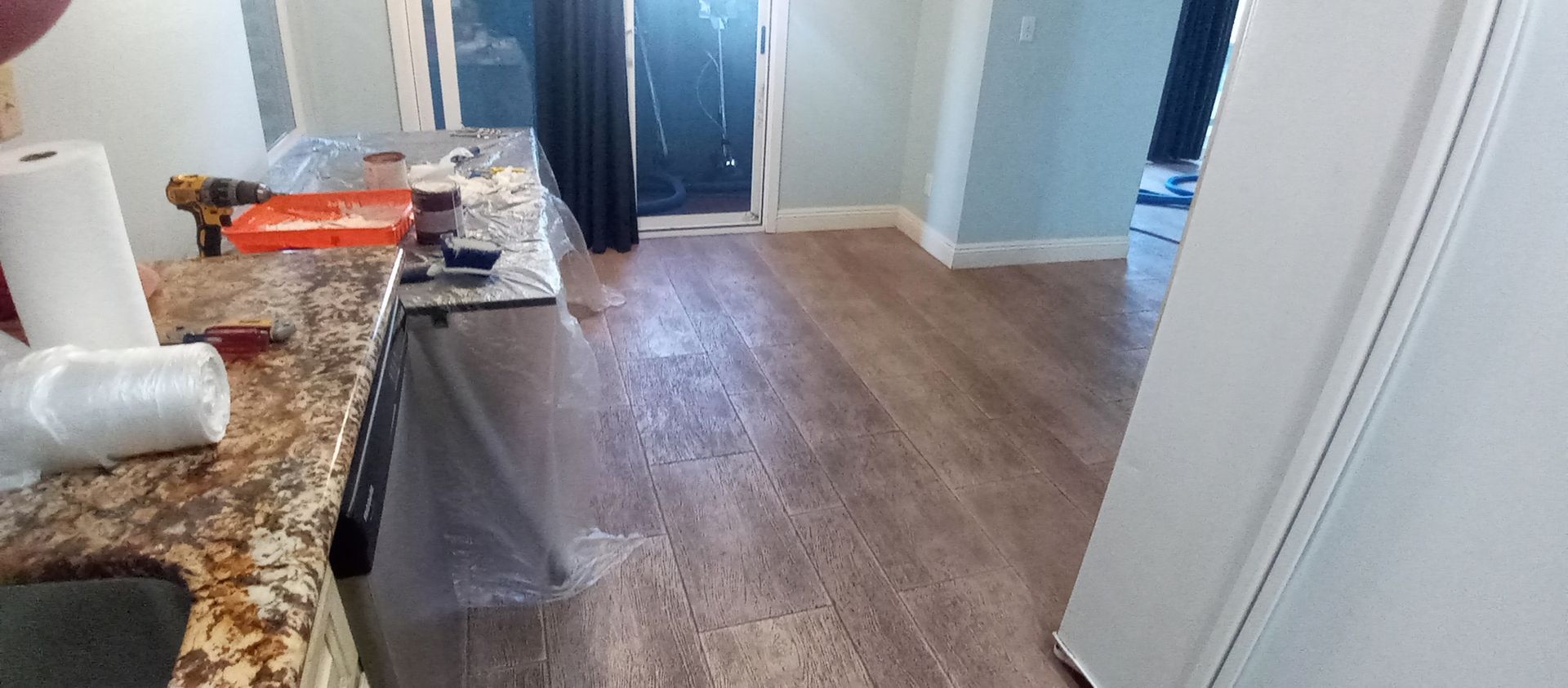 A kitchen with hardwood floors and a granite counter top.