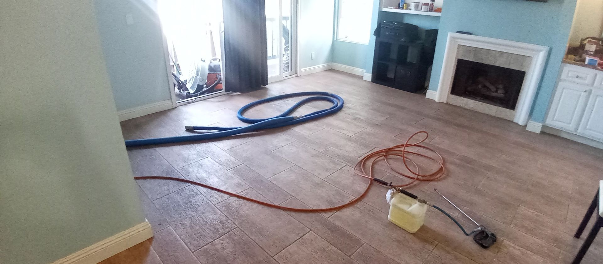 A living room with a fireplace and a vacuum cleaner on the floor.