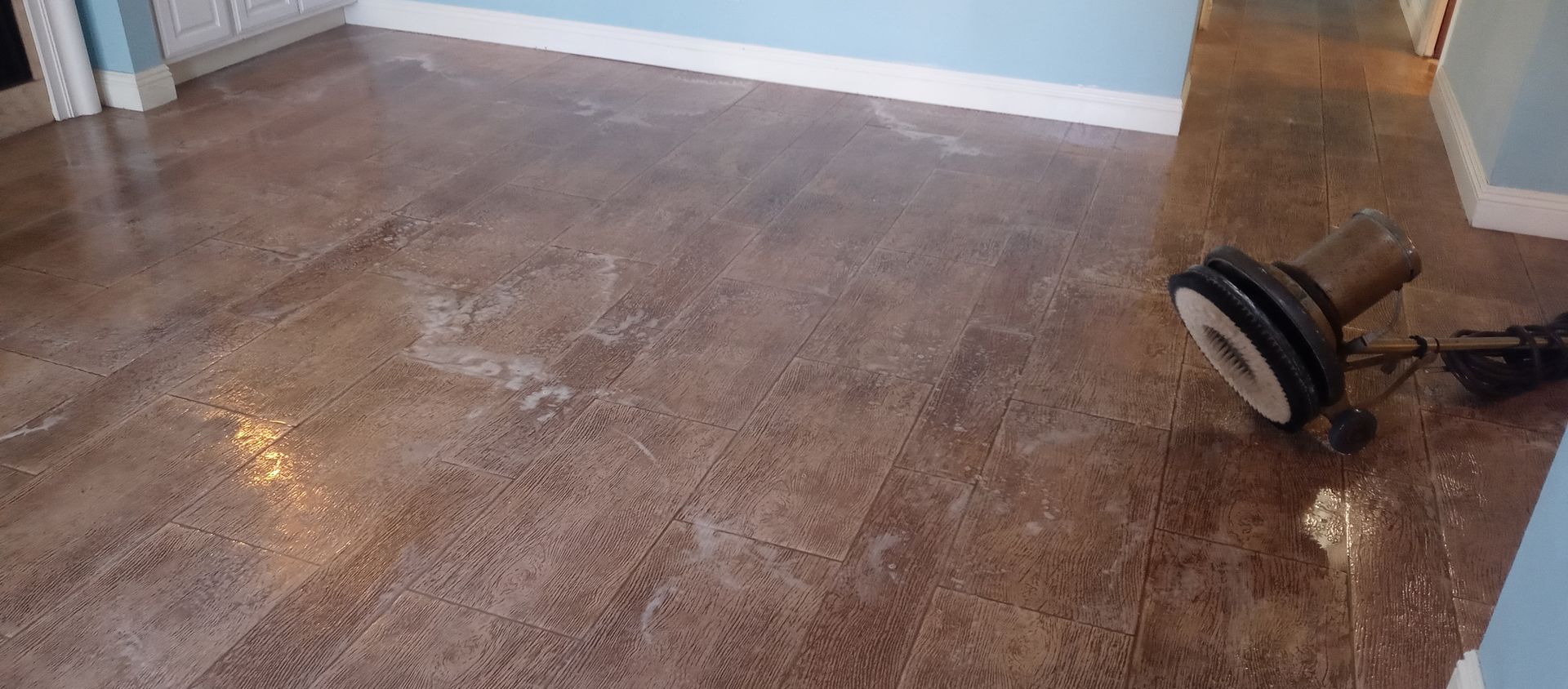 A vacuum cleaner is sitting on a wooden floor in a room.