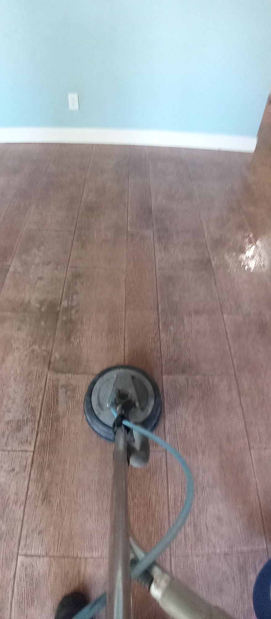 A vacuum cleaner is sitting on a tiled floor in a room.