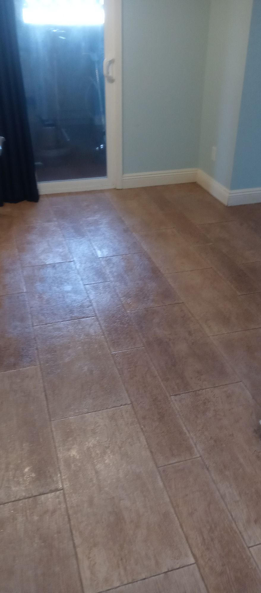 A room with a tiled floor and a sliding glass door.