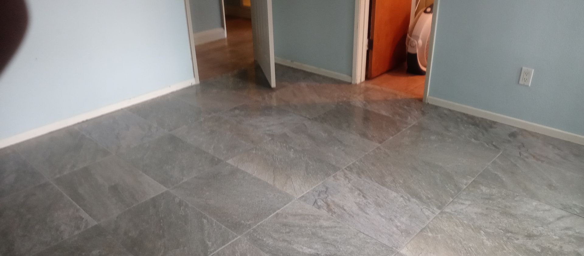 A room with a tiled floor and a door leading to a bathroom.