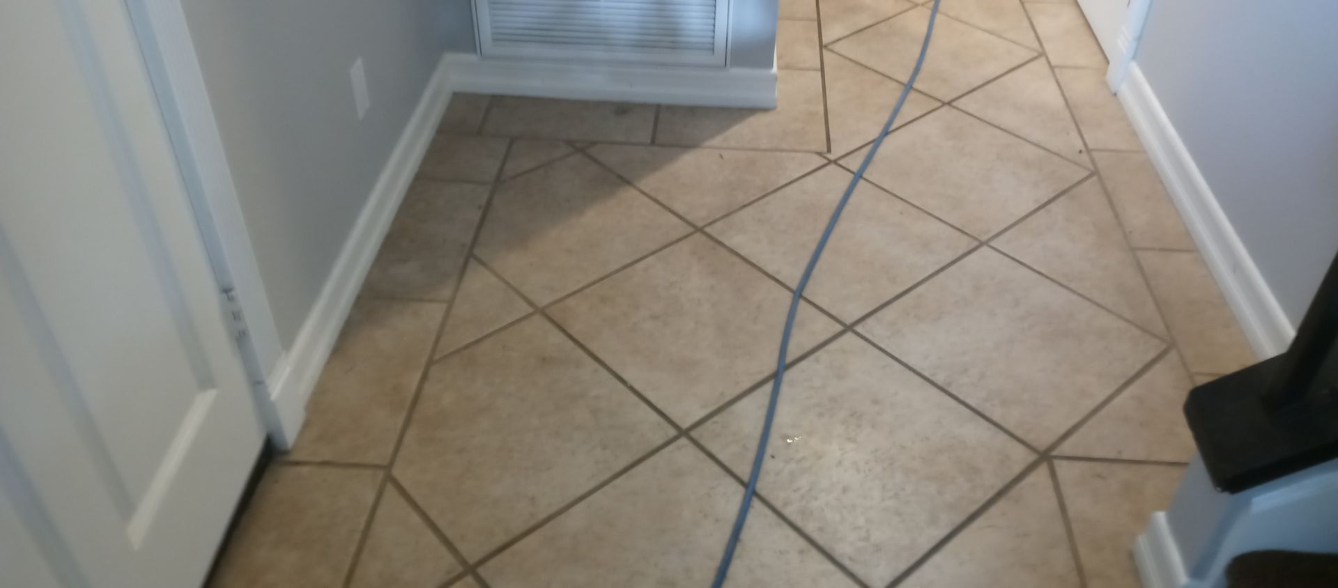 A tiled floor in a room with a vacuum cleaner on it.