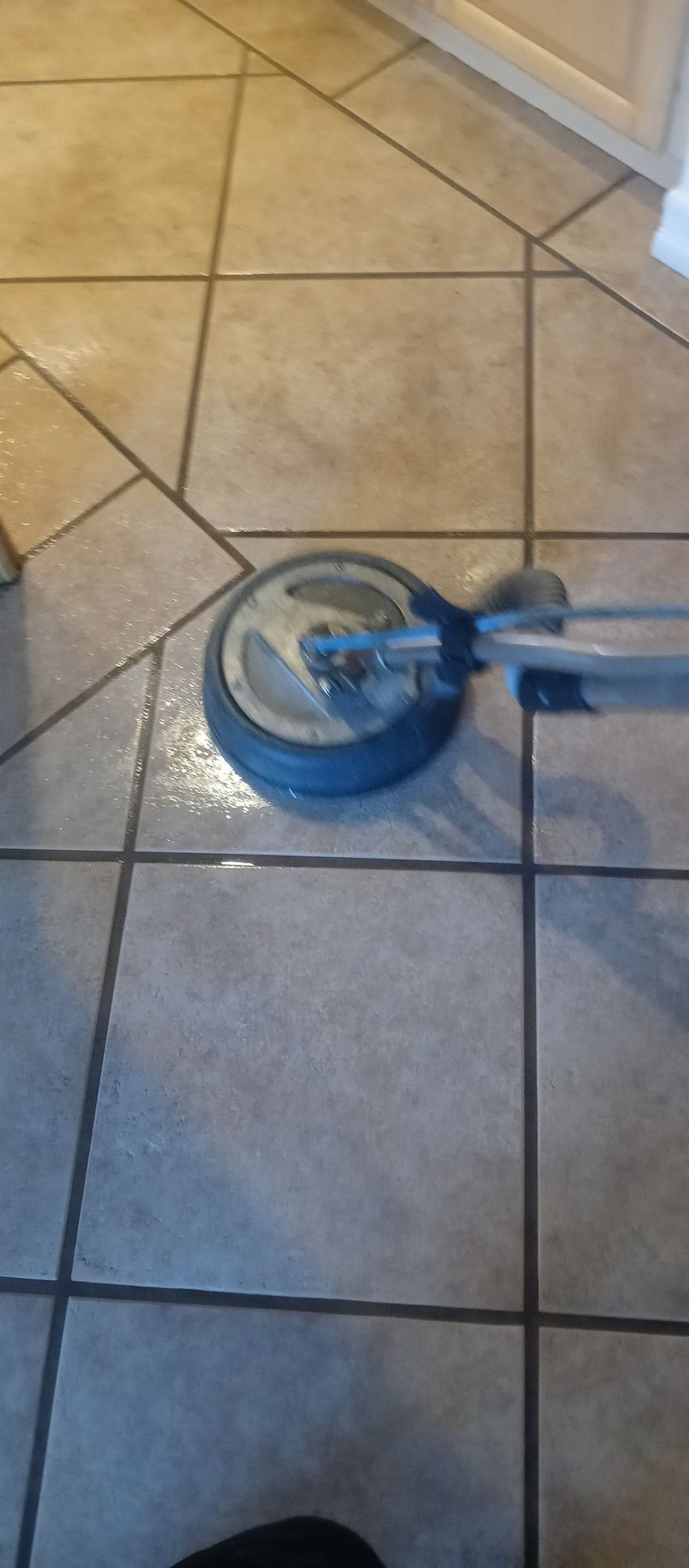 A scooter wheel is sitting on a tiled floor.