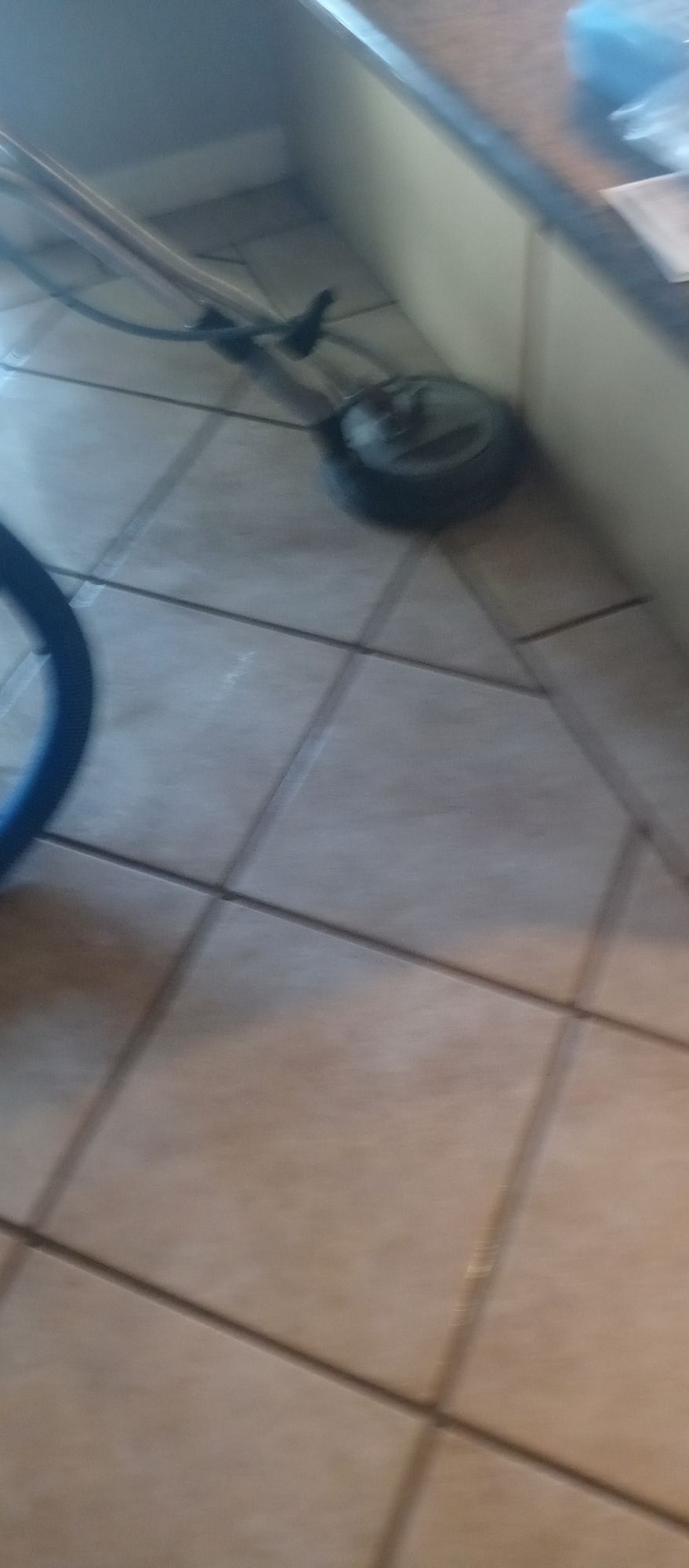 A vacuum cleaner is sitting on a tiled floor