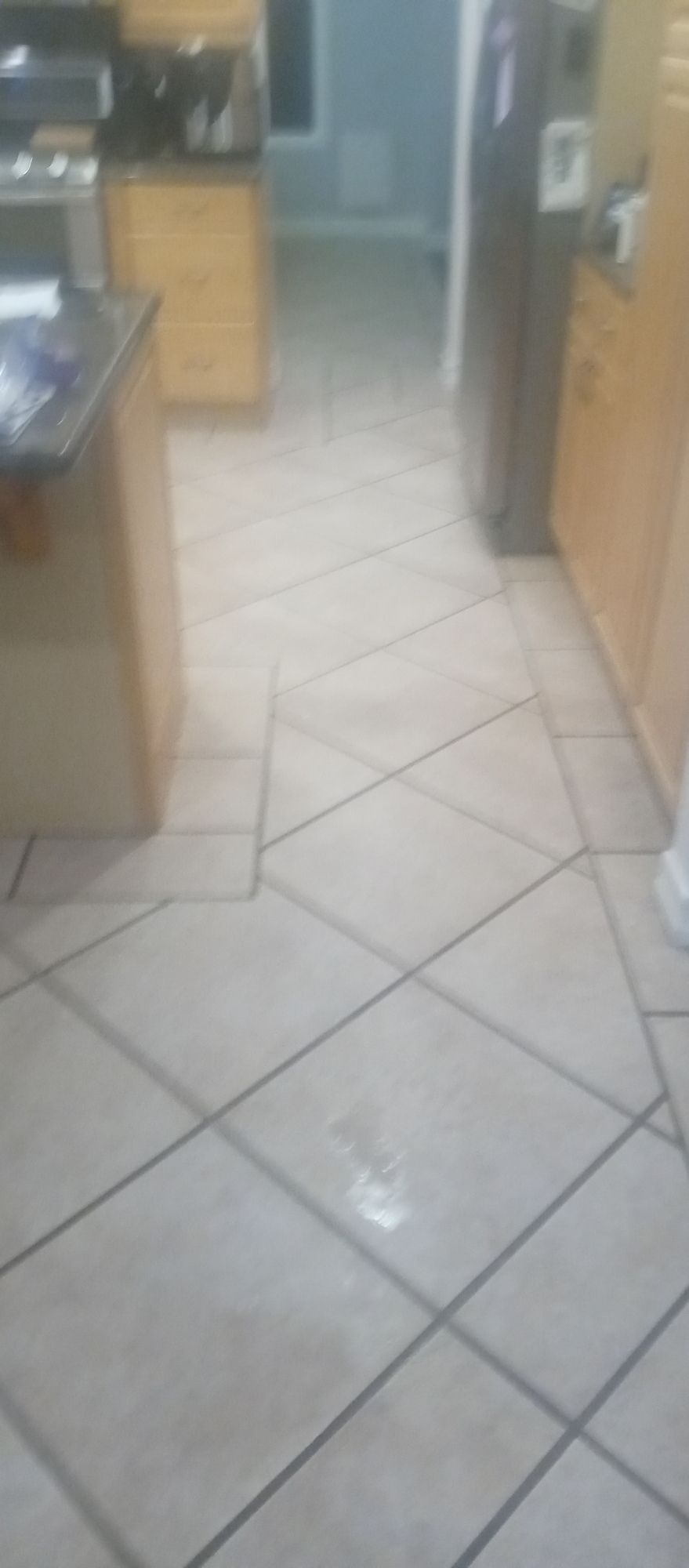 A kitchen with a tiled floor and a stove and refrigerator.