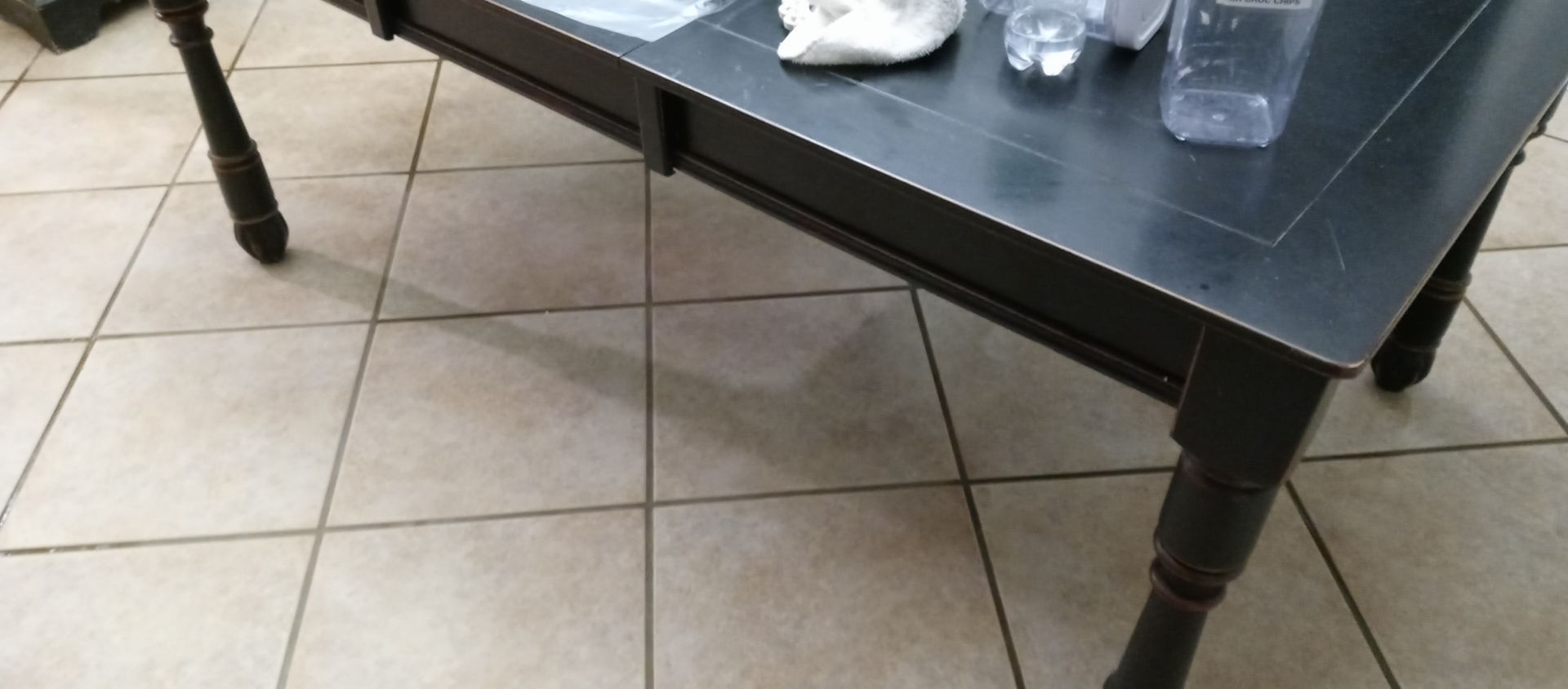 A black coffee table is sitting on a tiled floor.