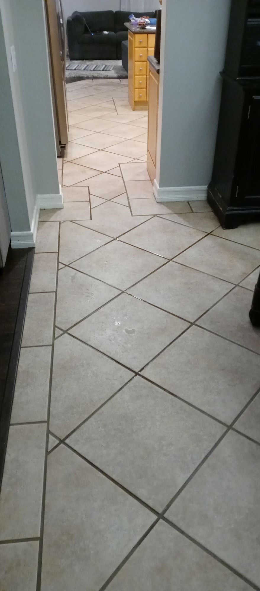A tiled floor in a living room with a diagonal pattern.