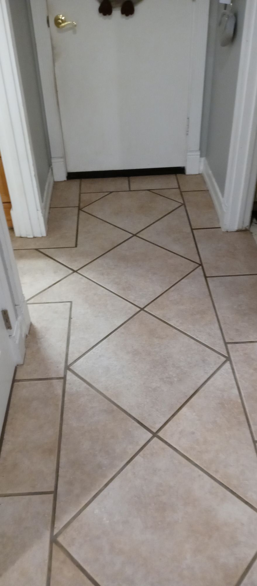 A hallway with a tiled floor and a door.