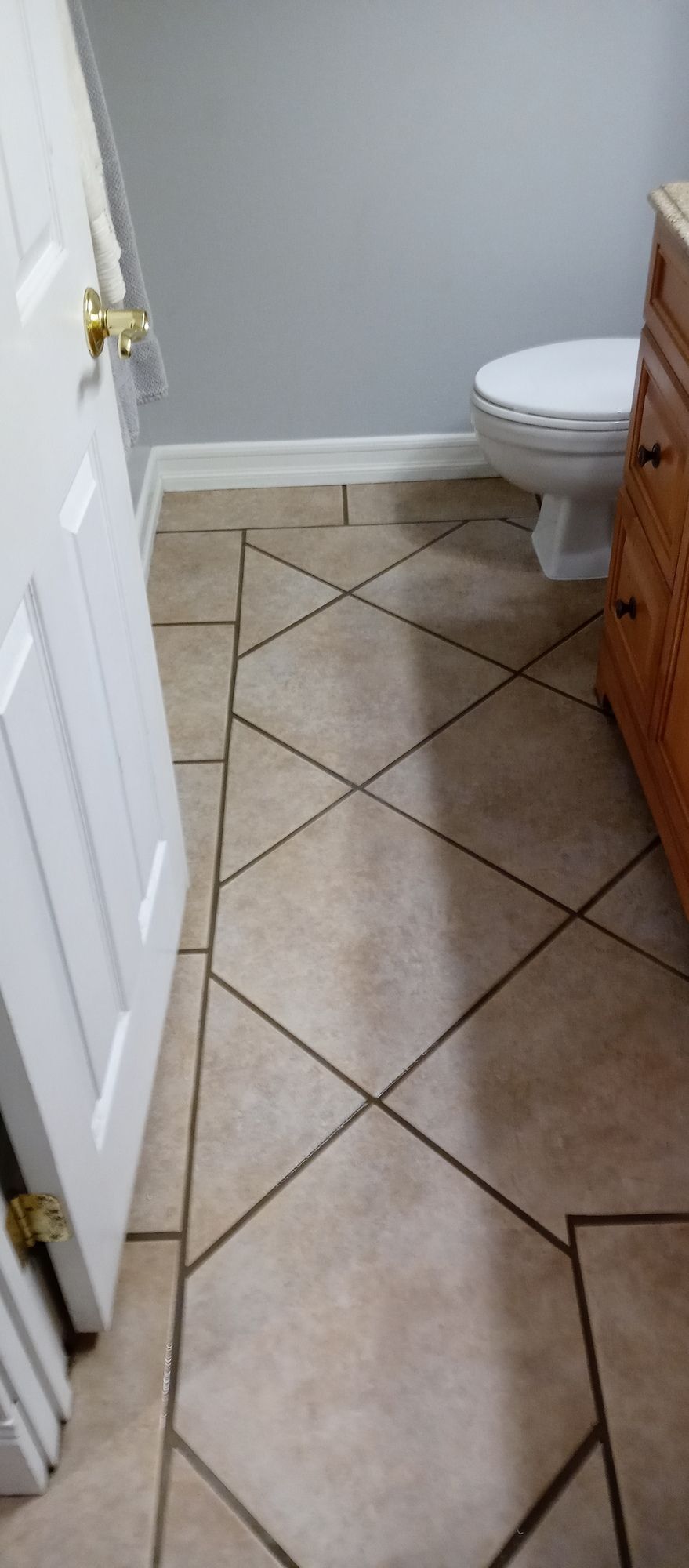 A bathroom with a tiled floor and a toilet.