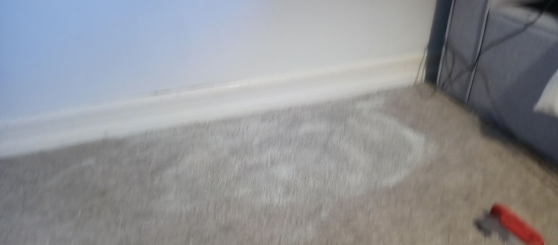 A person is standing on a carpeted floor in a room.