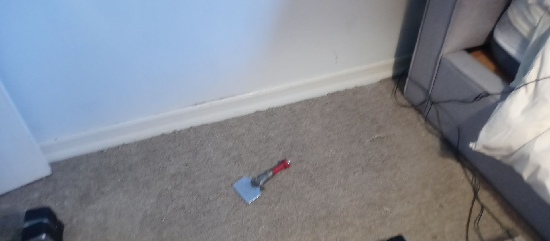 A spatula is laying on the floor in a bedroom next to a bed.