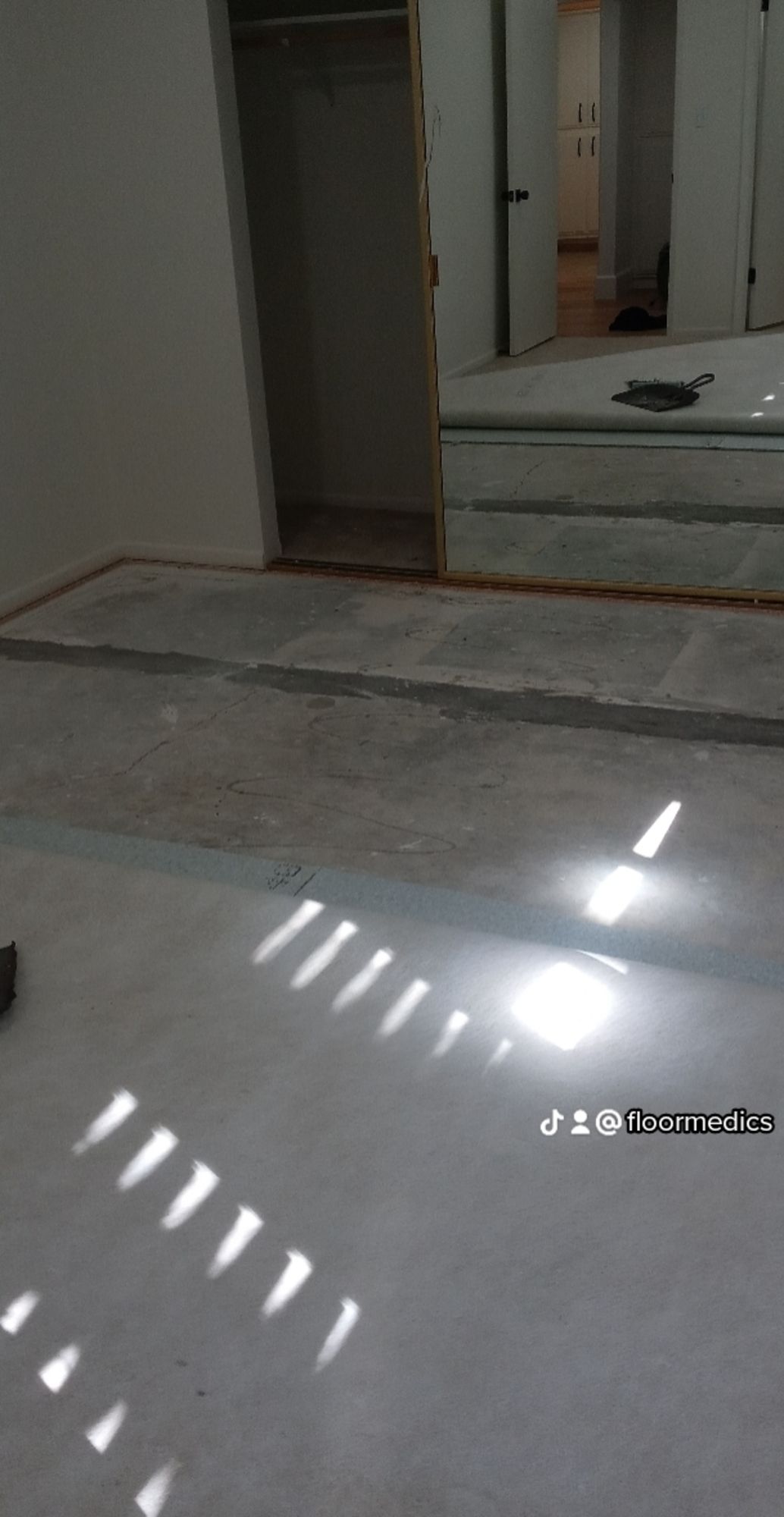 A room with a lot of mirrors and a light shining on the floor.