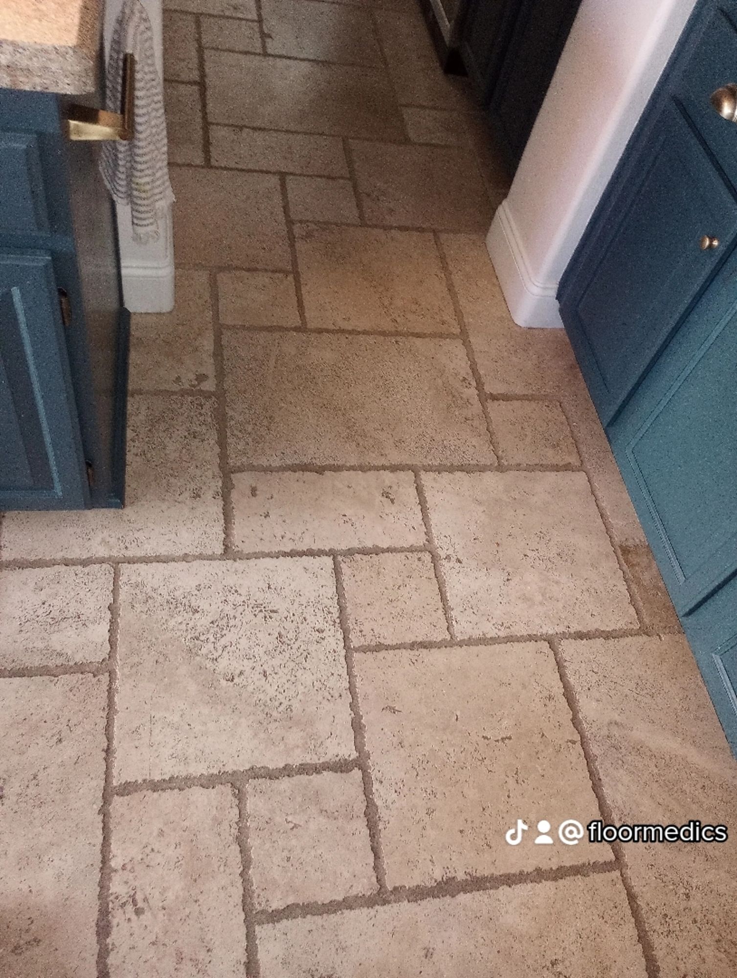 A kitchen with a tile floor and blue cabinets