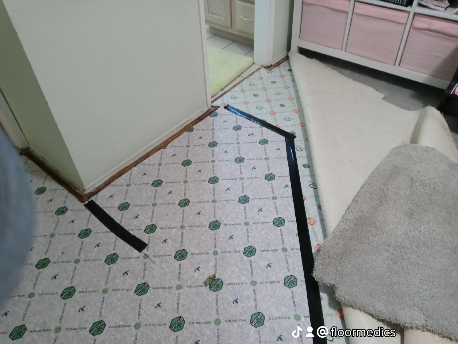 A room with a tile floor and black tape on it