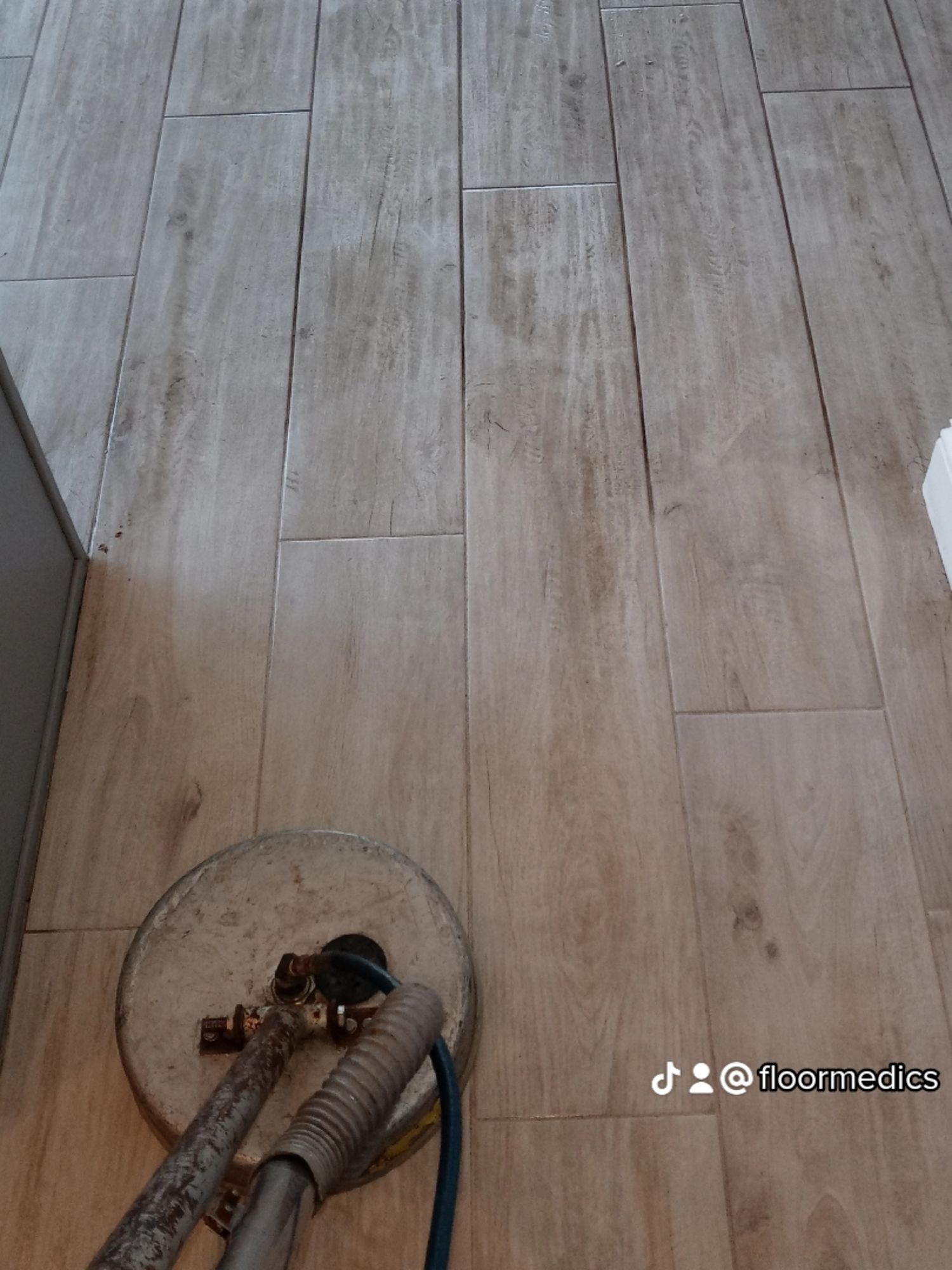 A metal detector is sitting on a wooden floor.