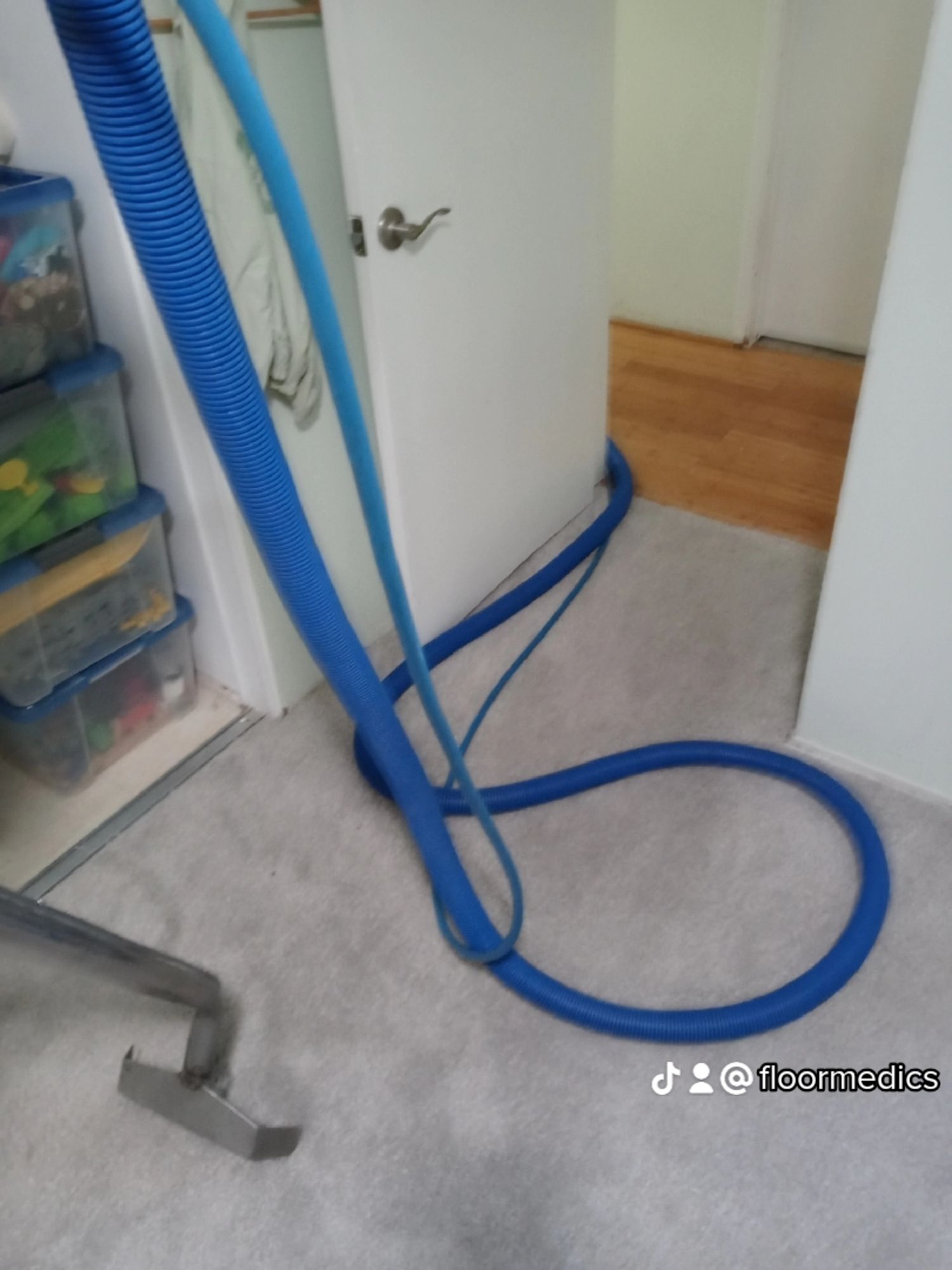 A blue hose is connected to a vacuum cleaner