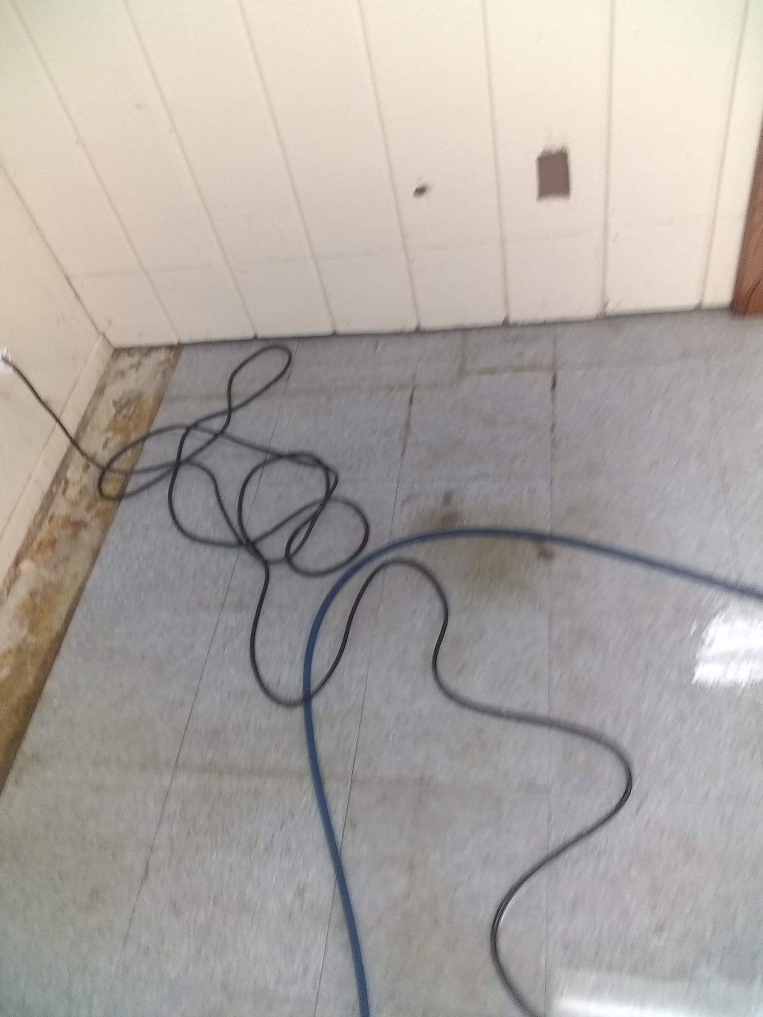 A power cord is laying on the floor in a room