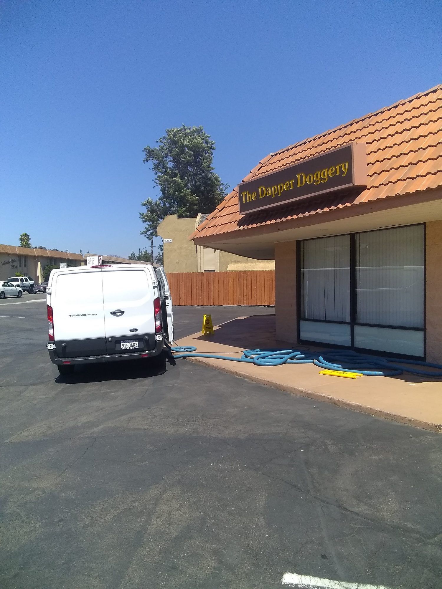 A white van is parked in front of a building with a sign that says mrs. cupcake donuts