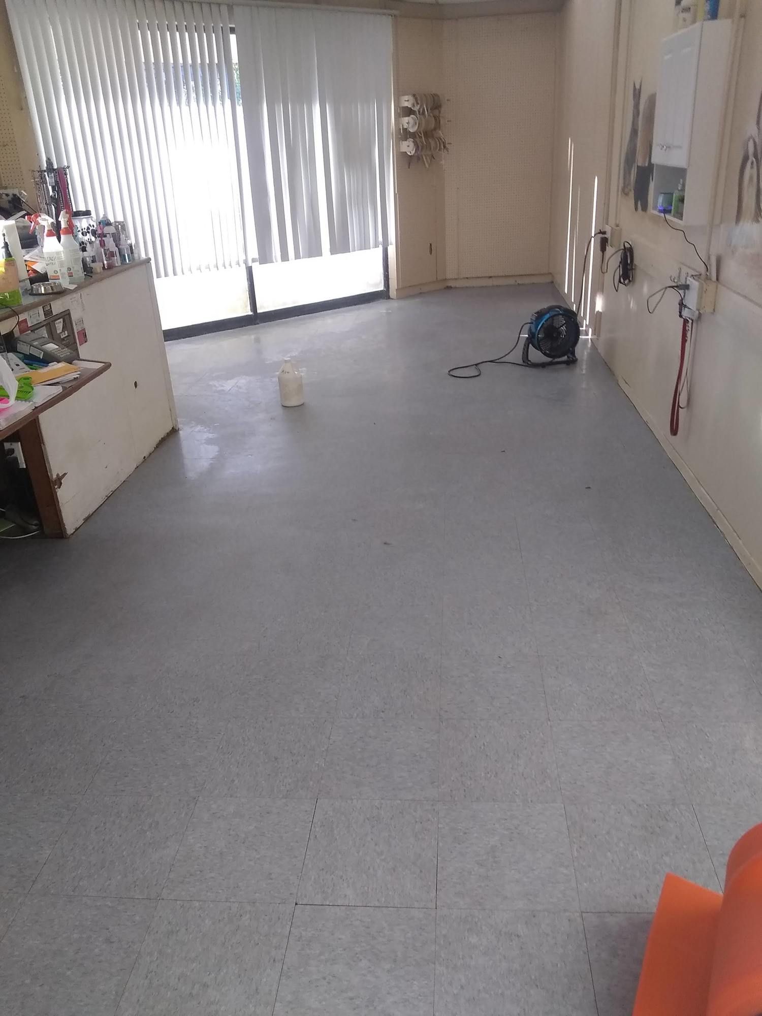 A large empty room with a vacuum cleaner on the floor.