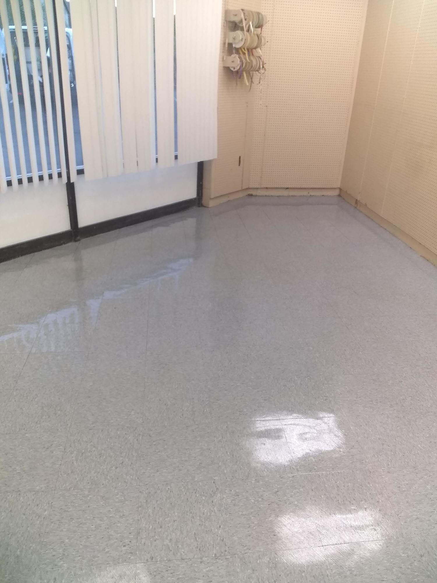 A room with a gray floor and white blinds