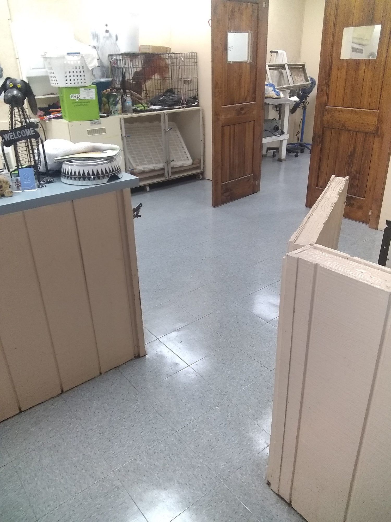 A veterinarian 's office with a desk and a cage.
