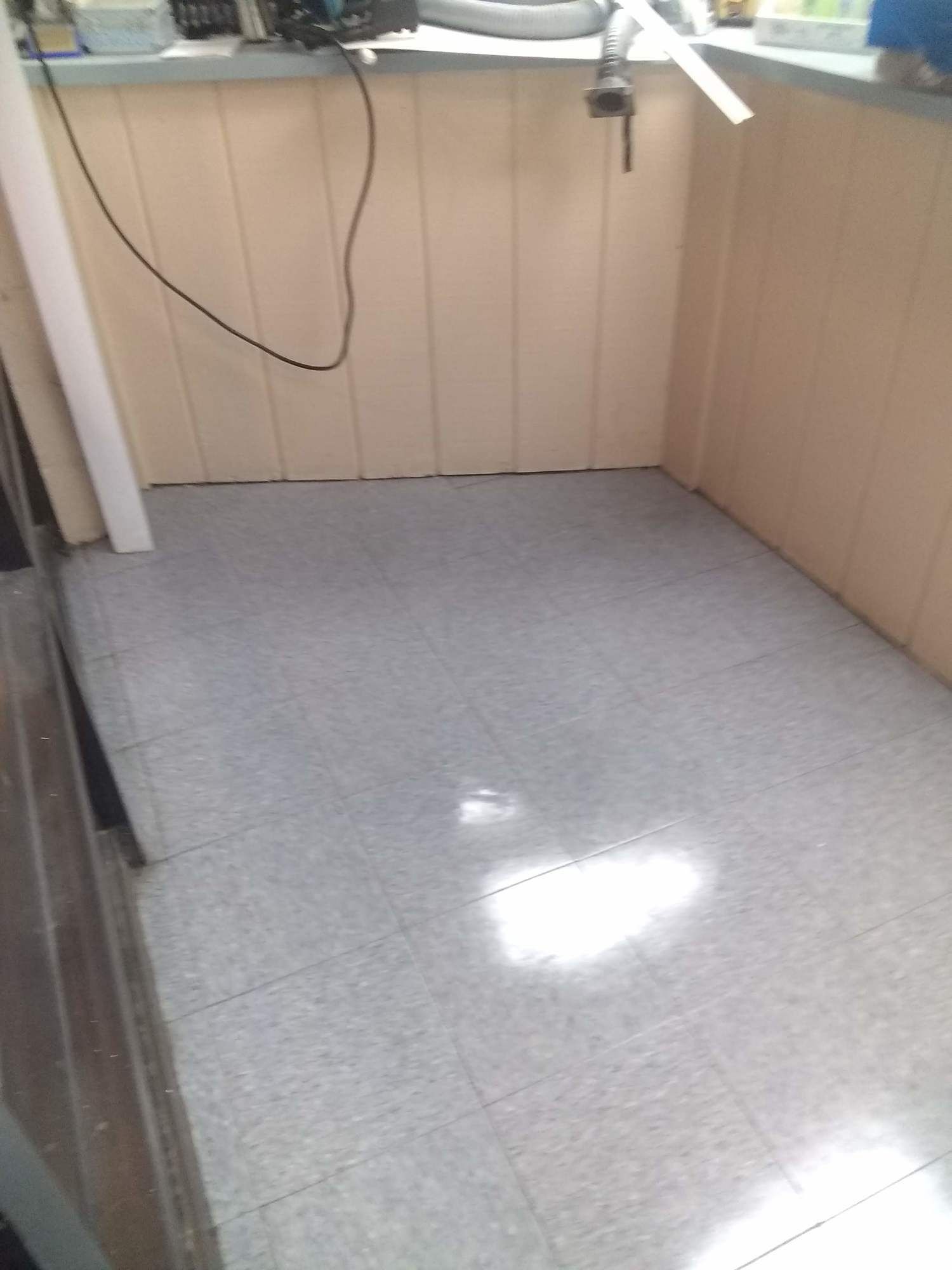 A room with a white tile floor and a white wall.