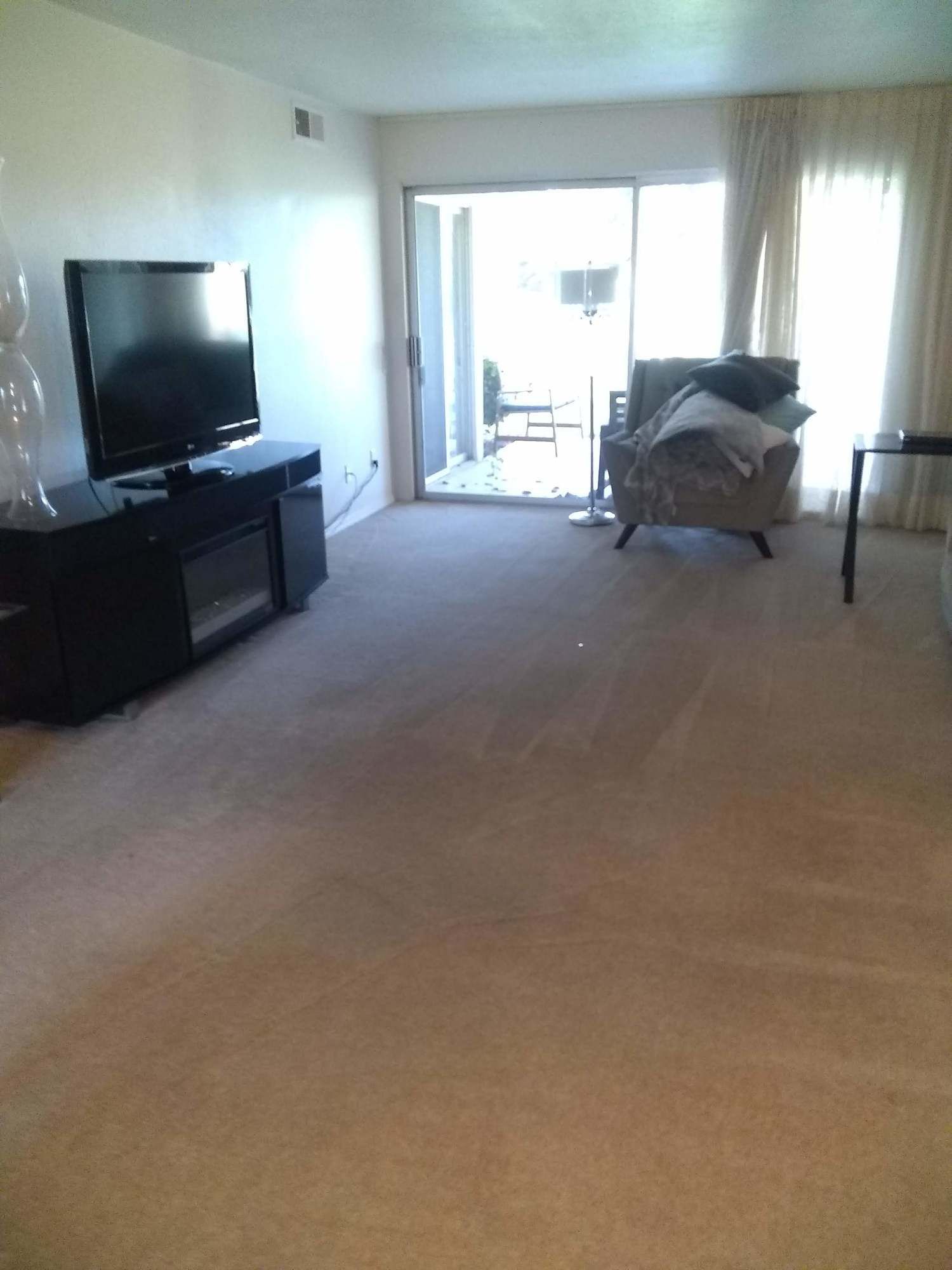 A living room with a flat screen tv and a chair