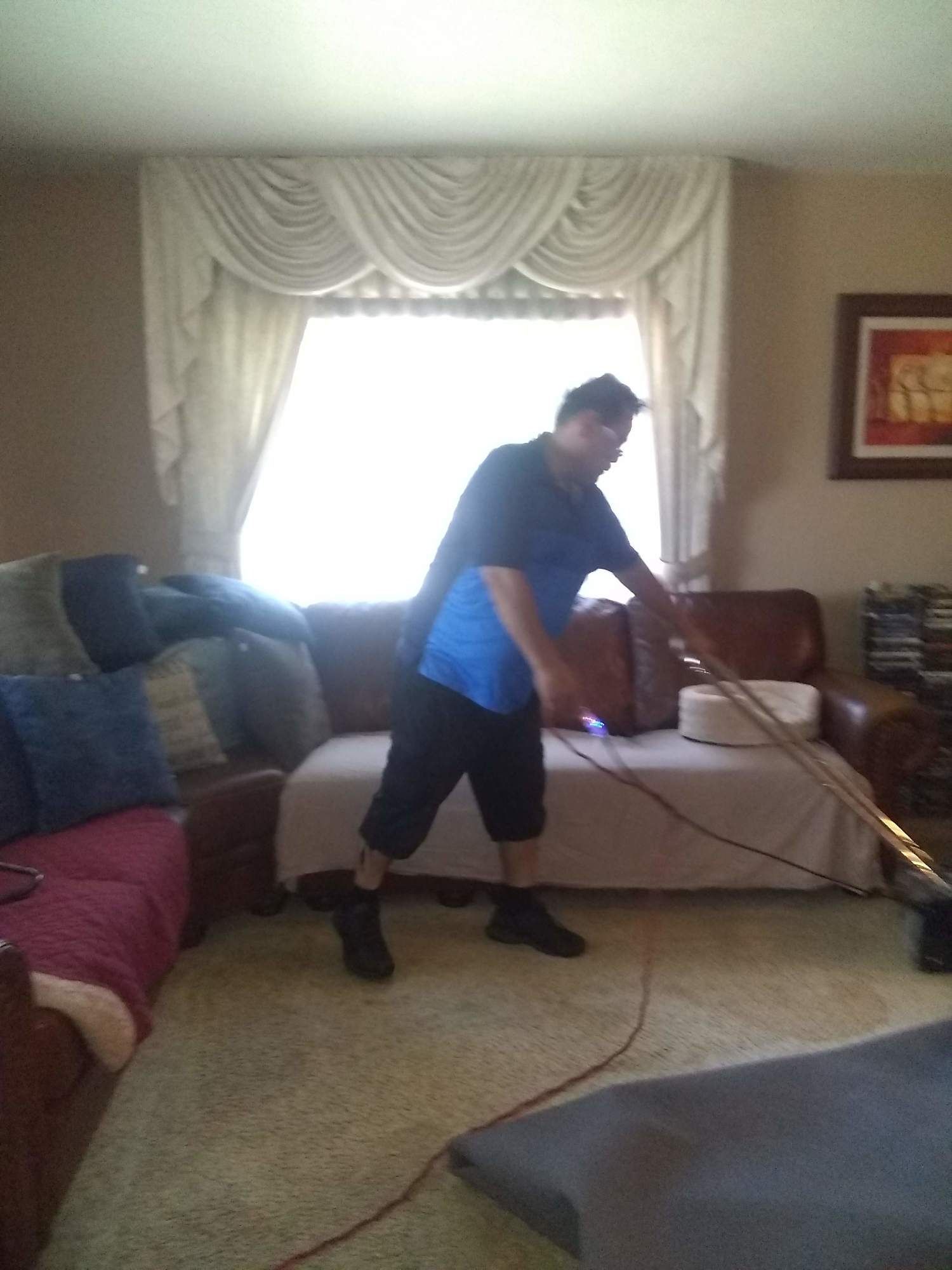 A man is using a vacuum cleaner in a living room