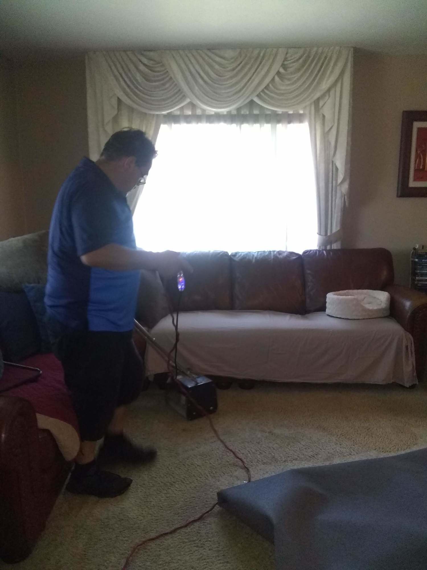 A man is standing in front of a couch in a living room.