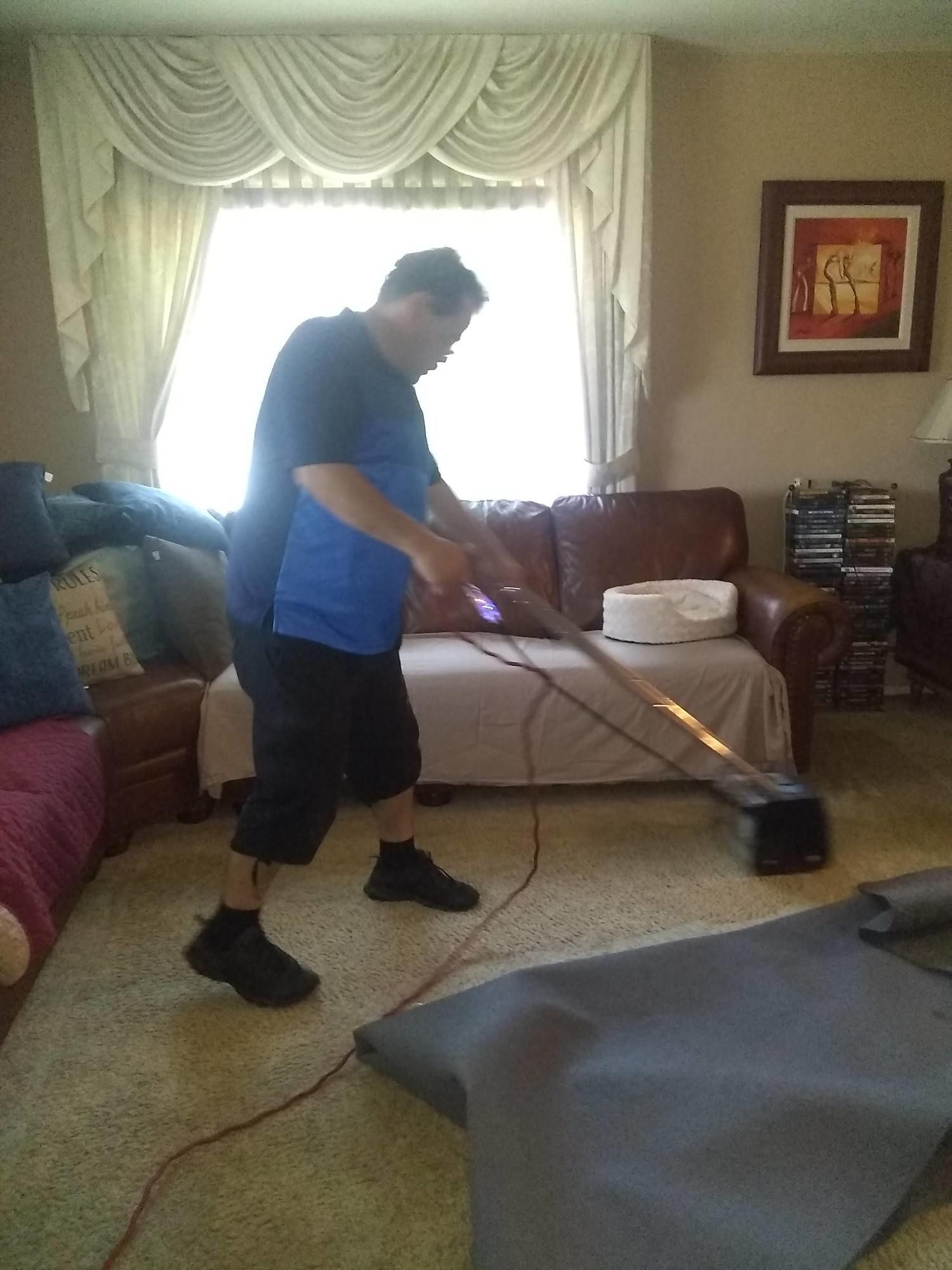 A man is using a vacuum cleaner in a living room