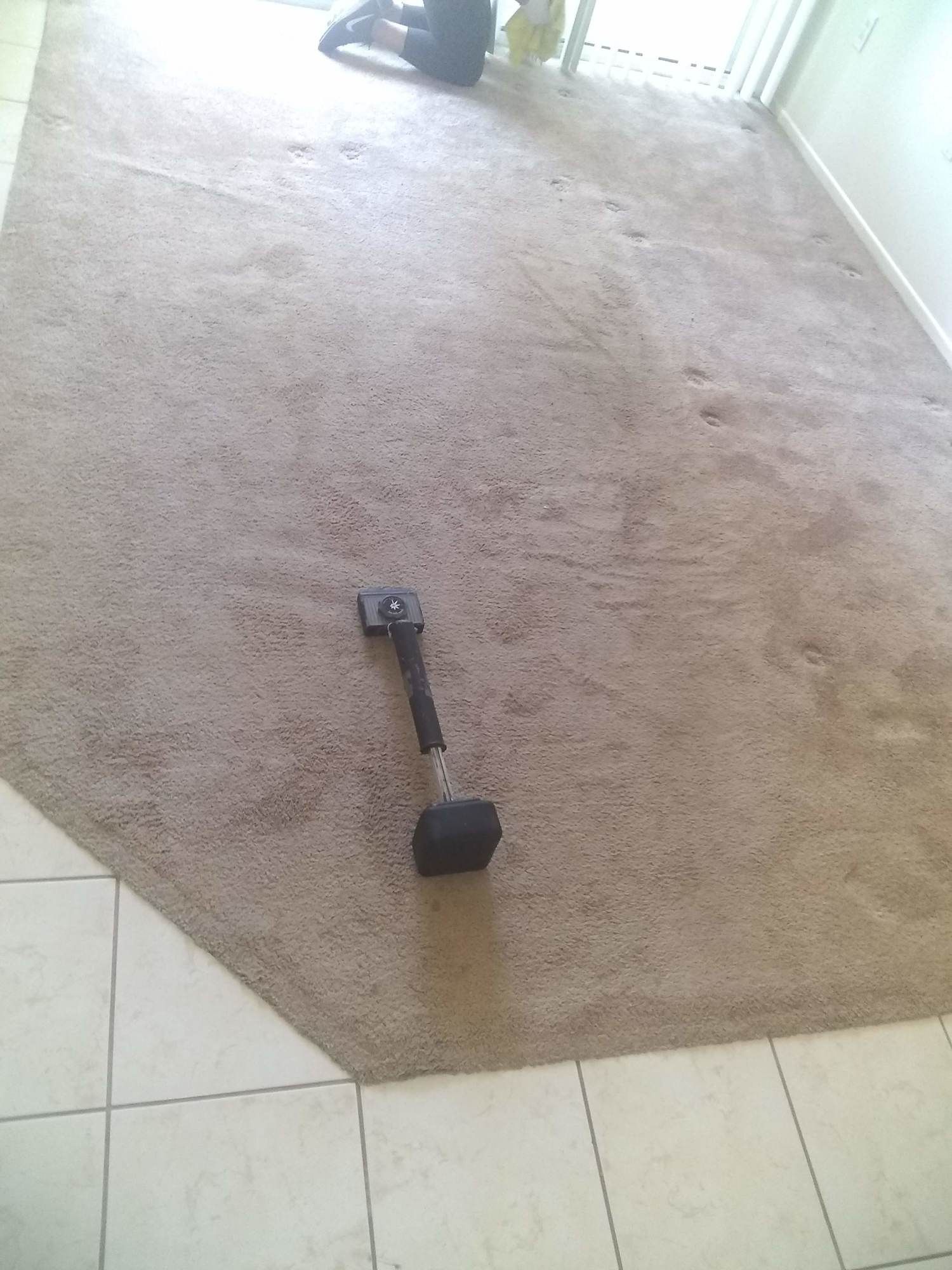 A hammer is laying on a carpet in a room
