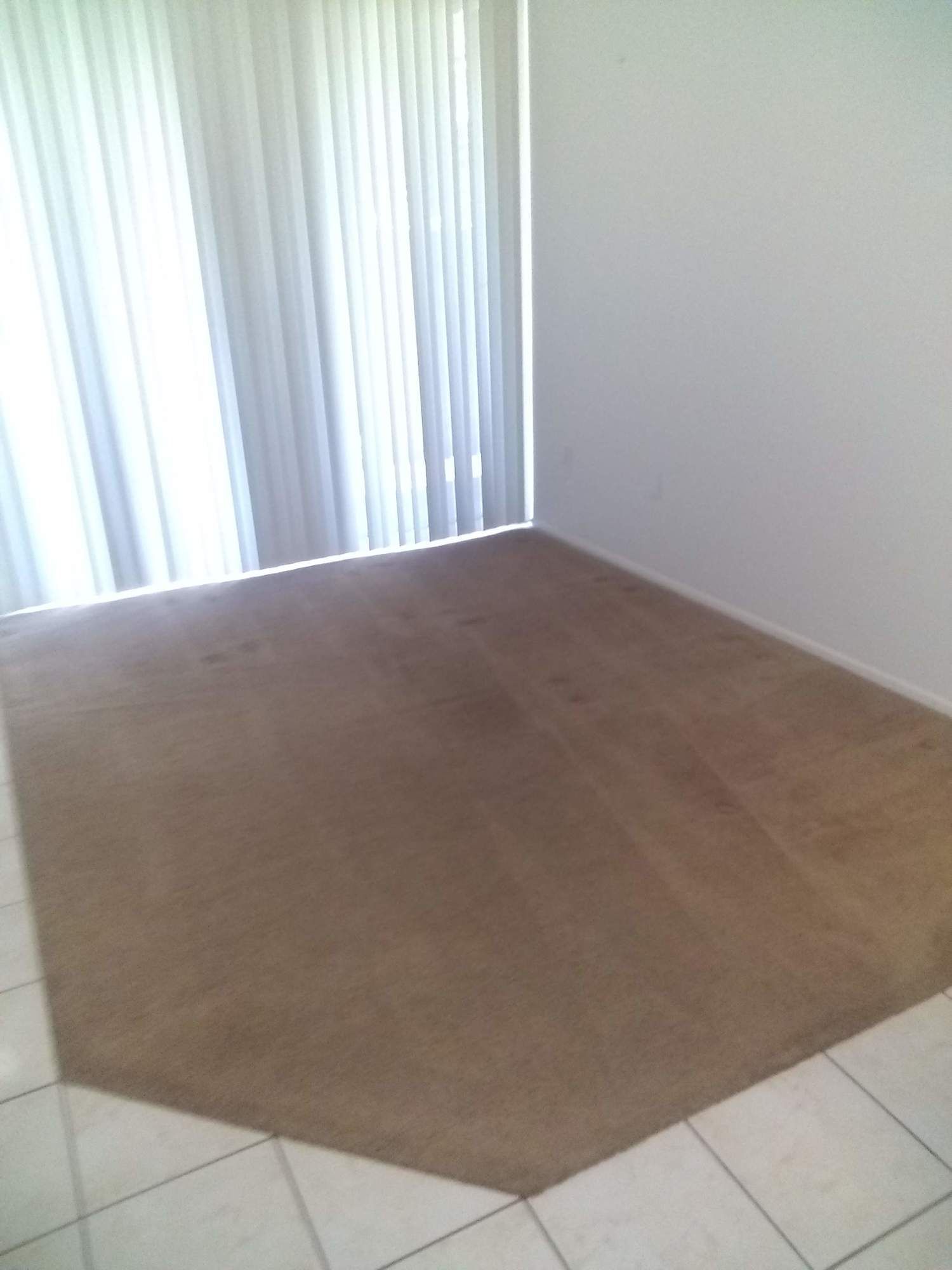 There is a rug on the floor in the corner of the room.