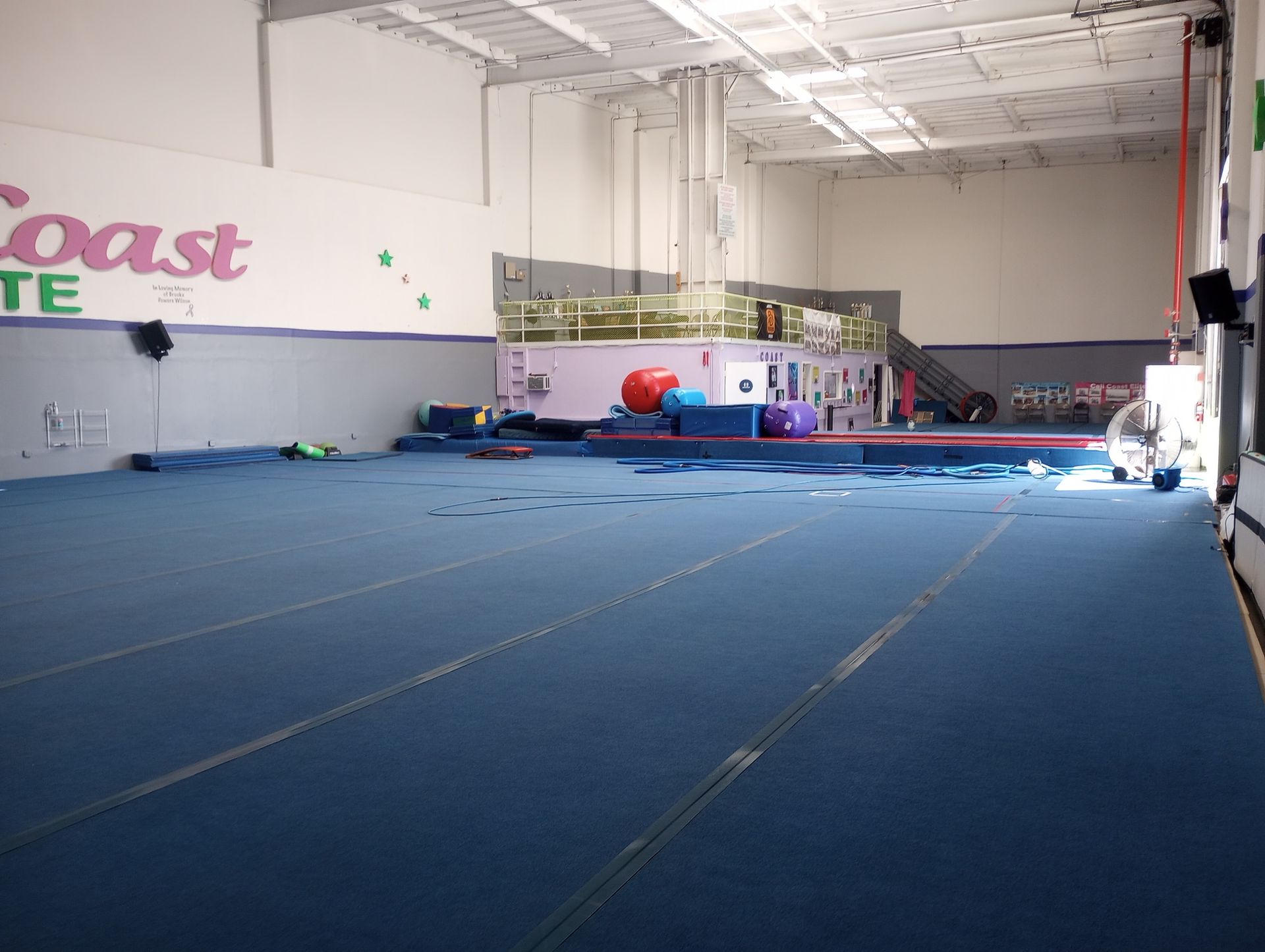 An empty gym with the word coast on the wall
