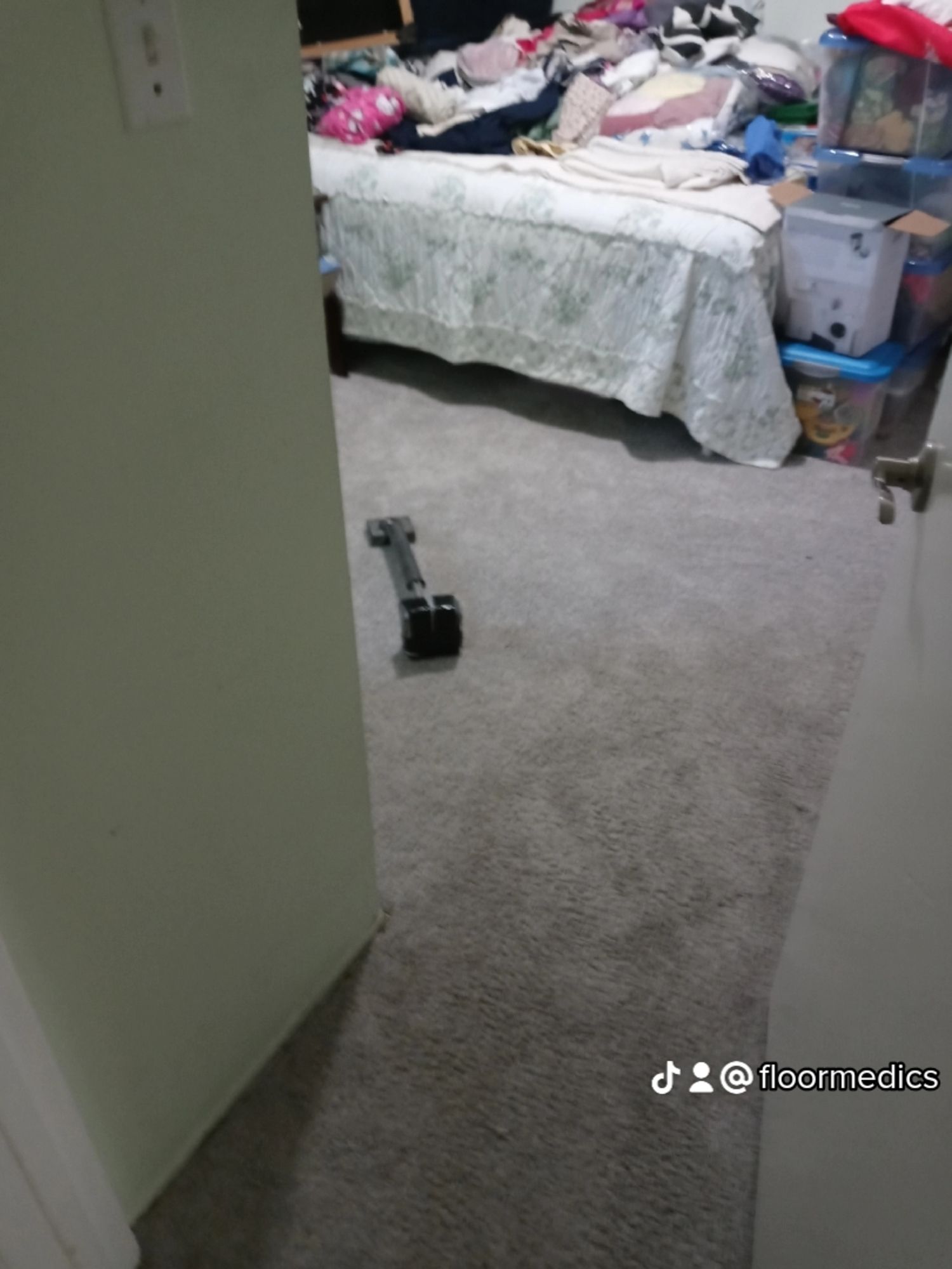 A bedroom with a bed and a dumbbell on the floor