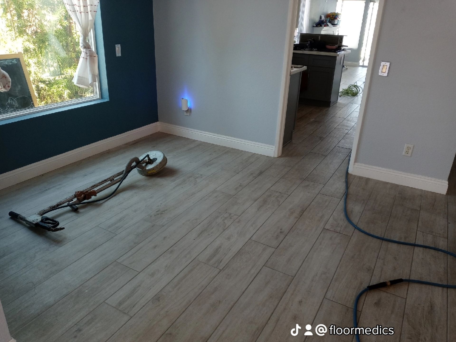 A vacuum cleaner is sitting on a wooden floor in a room.