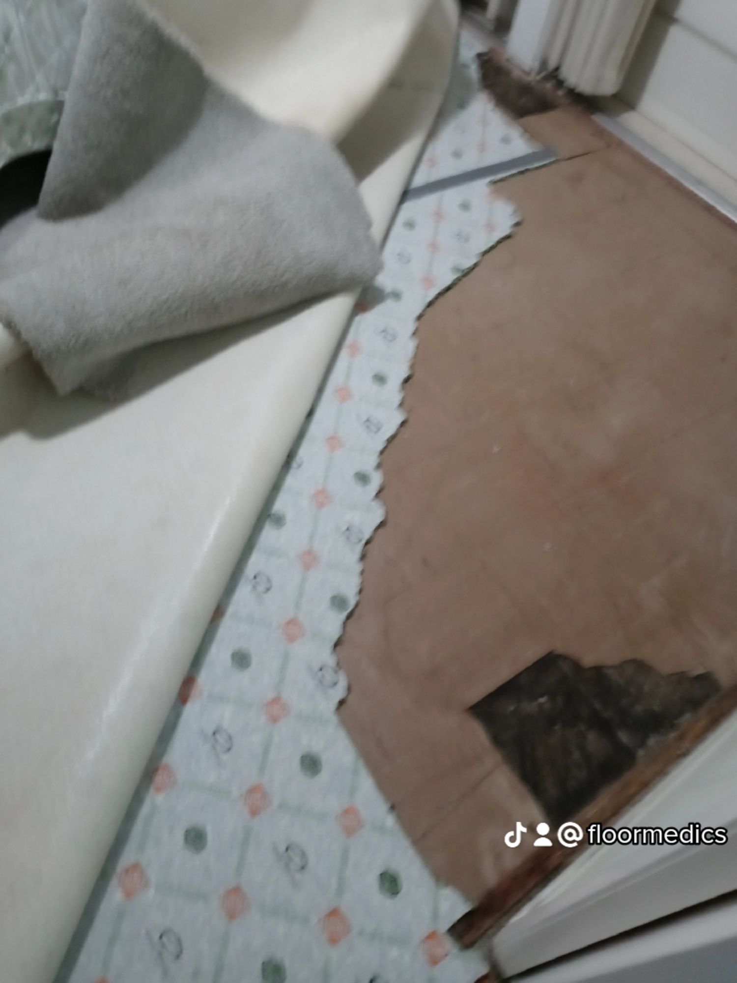 A piece of paper is laying on the floor next to a sink