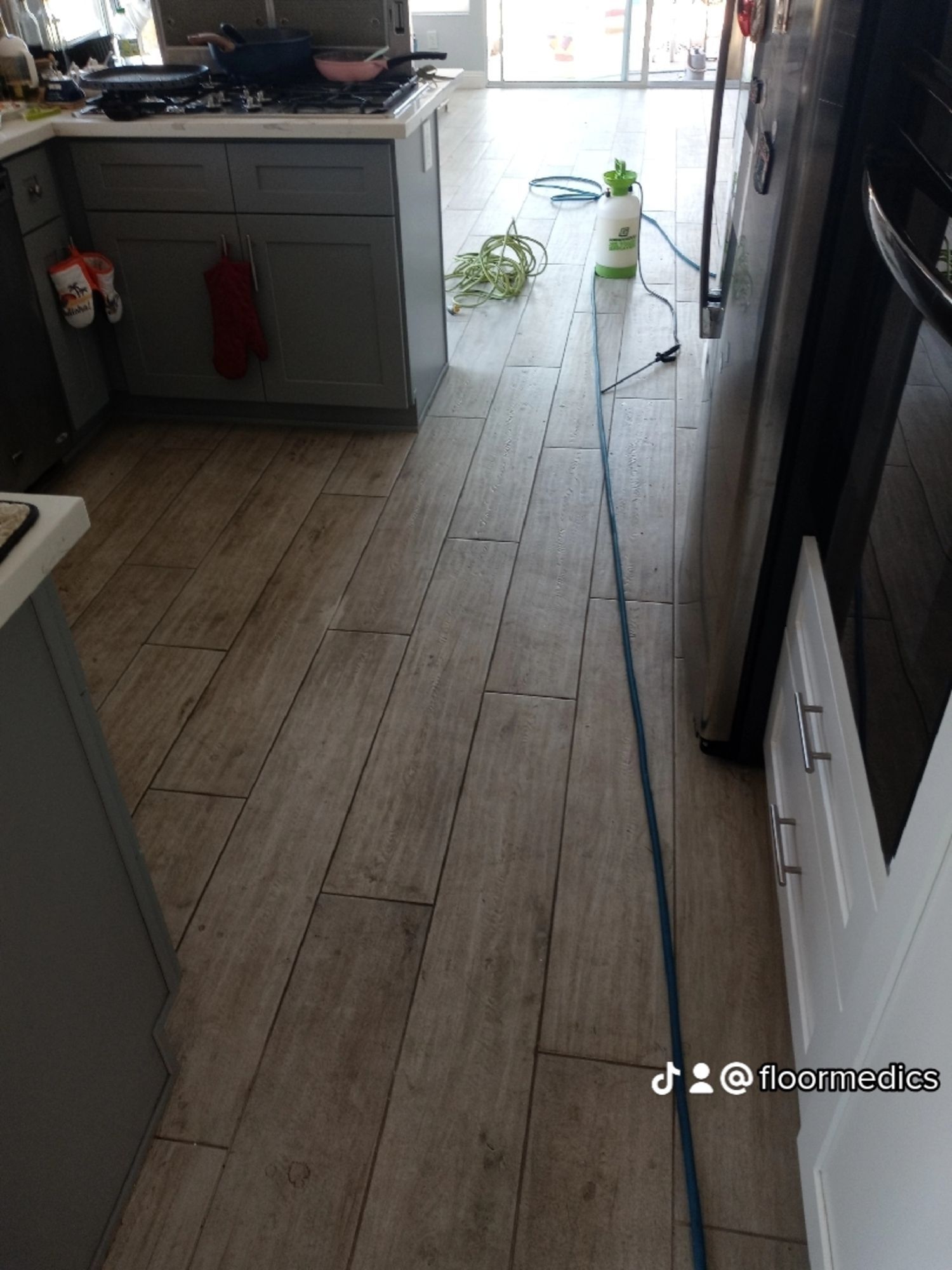 A kitchen with a wooden floor and a refrigerator.