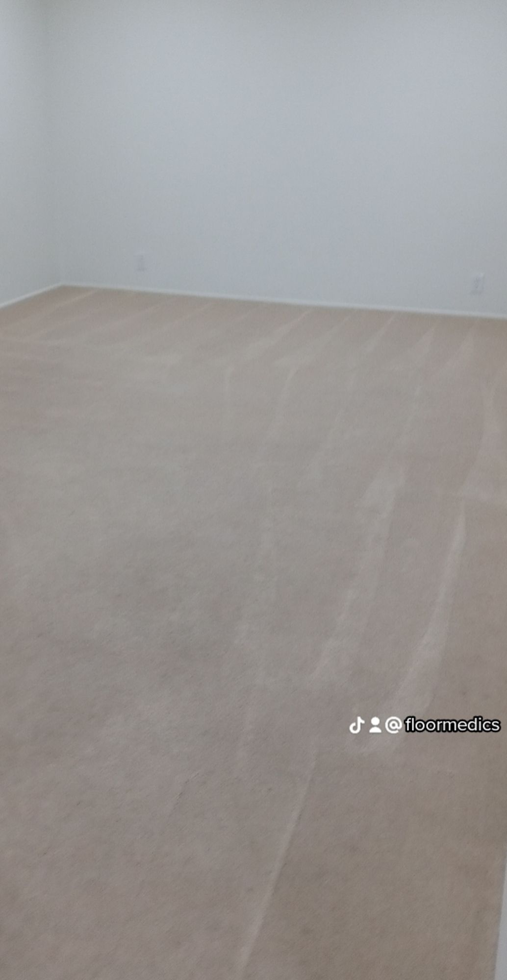 A large empty room with a carpeted floor and white walls.