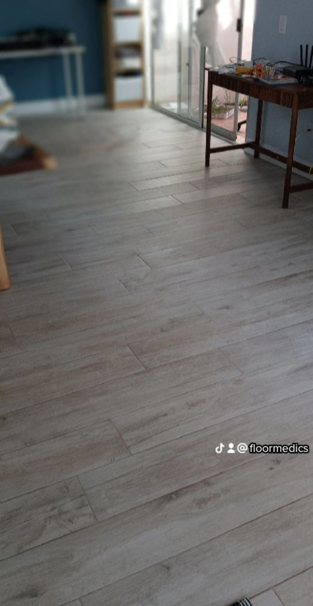 A living room with a wooden floor and a desk.
