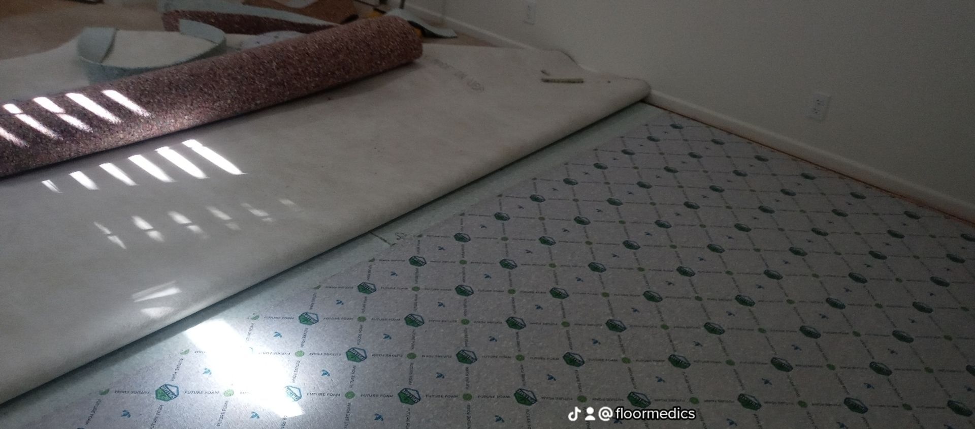 A roll of carpet is sitting on top of a cutting board.