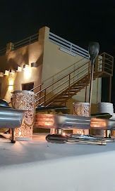 Buffet set up outdoors at night, with building and stairs in background.